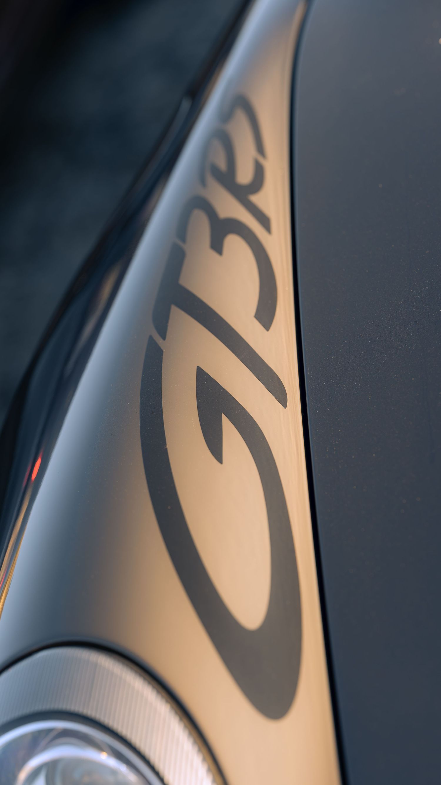Close-up detail of GT3 lettering on silver car body panel.