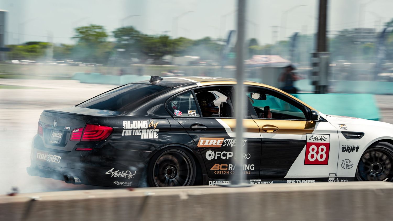 Two BMW drift cars, including car 88, slide through smoky turns at a professional motorsport drifting competition.