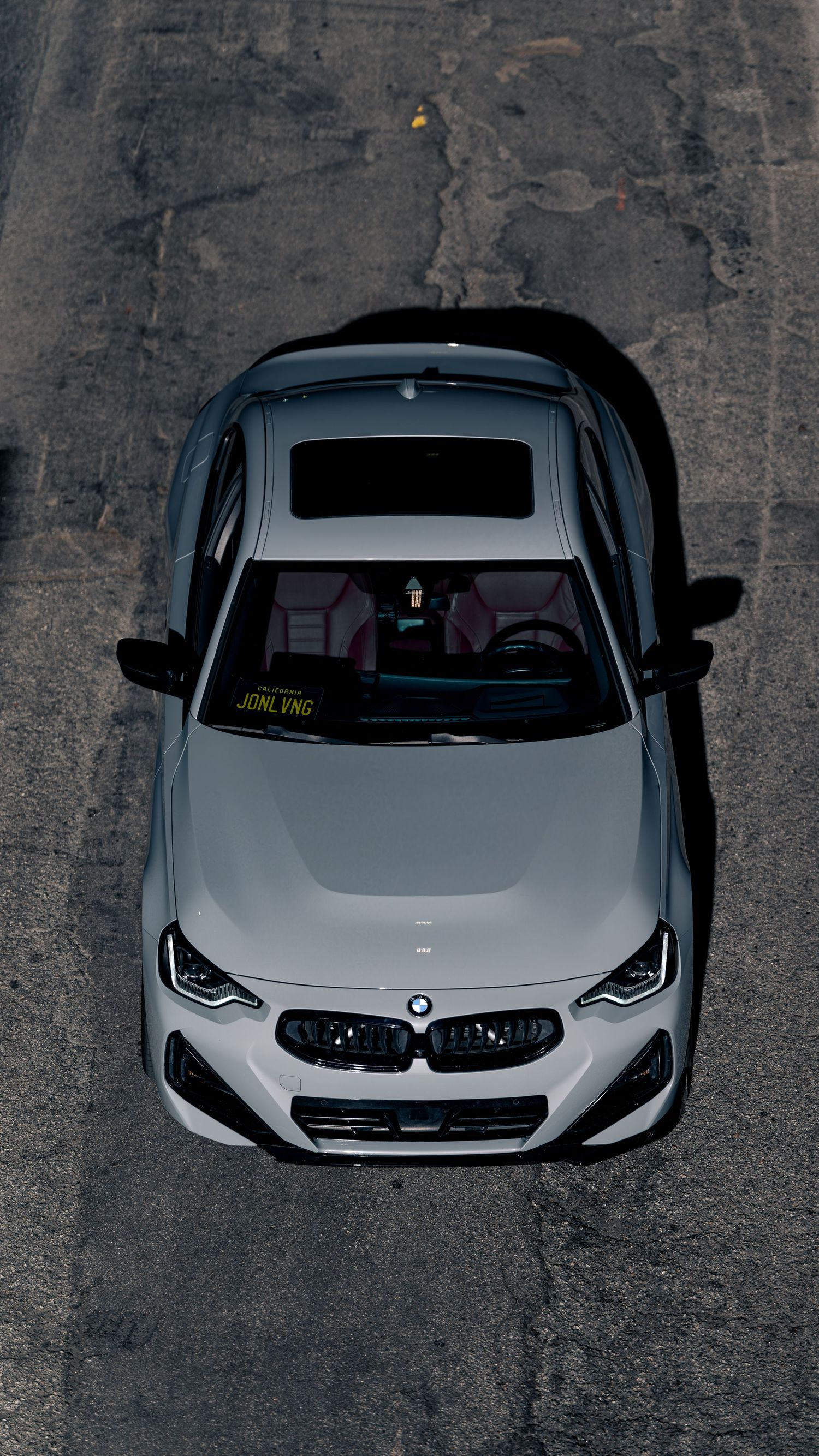 Overhead view of a white BMW M car showing its distinctive front-end design and hood.