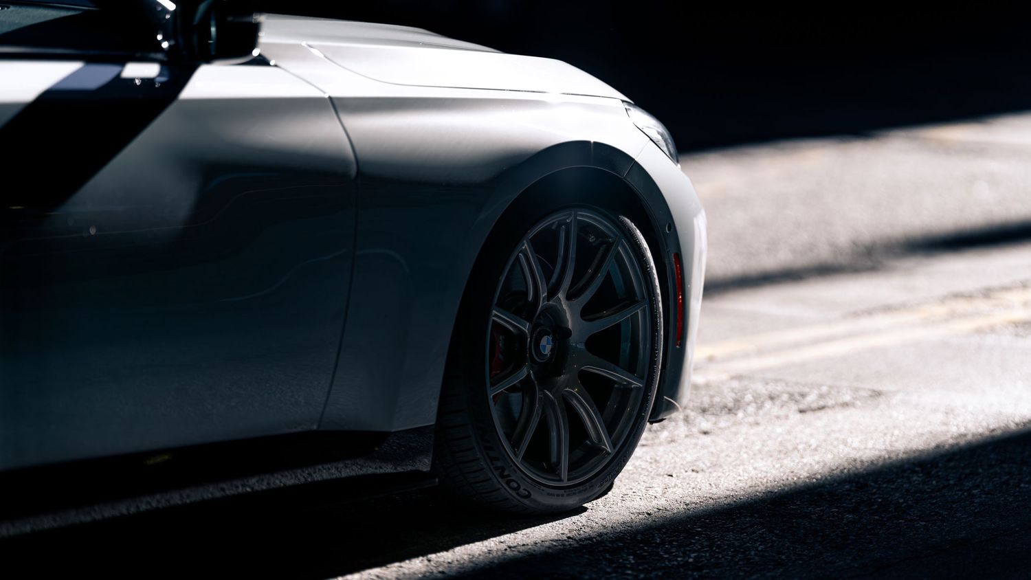 Minimalist detail shots highlighting the wheels and side profile of a BMW performance vehicle.