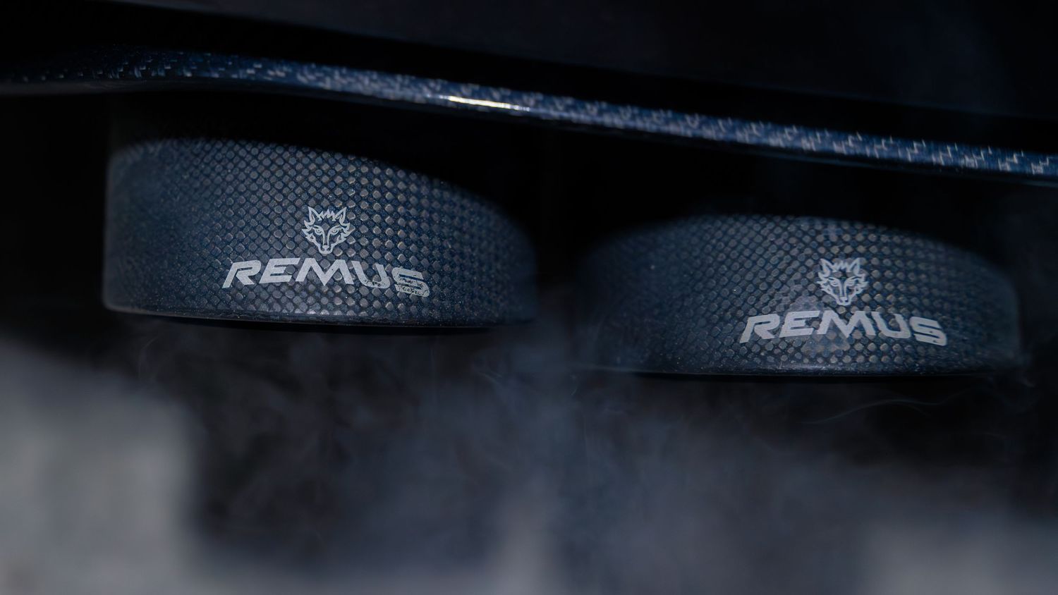 Close-up detail of a Remus performance exhaust system on a sports car.