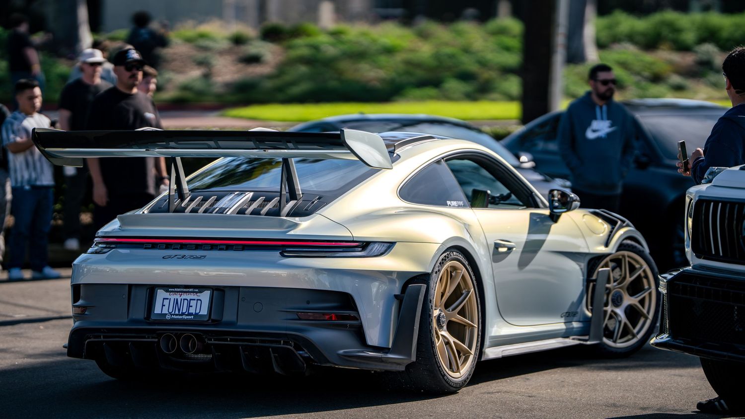 Row of high-performance sports cars parked at a car meet showing sleek designs and custom modifications.