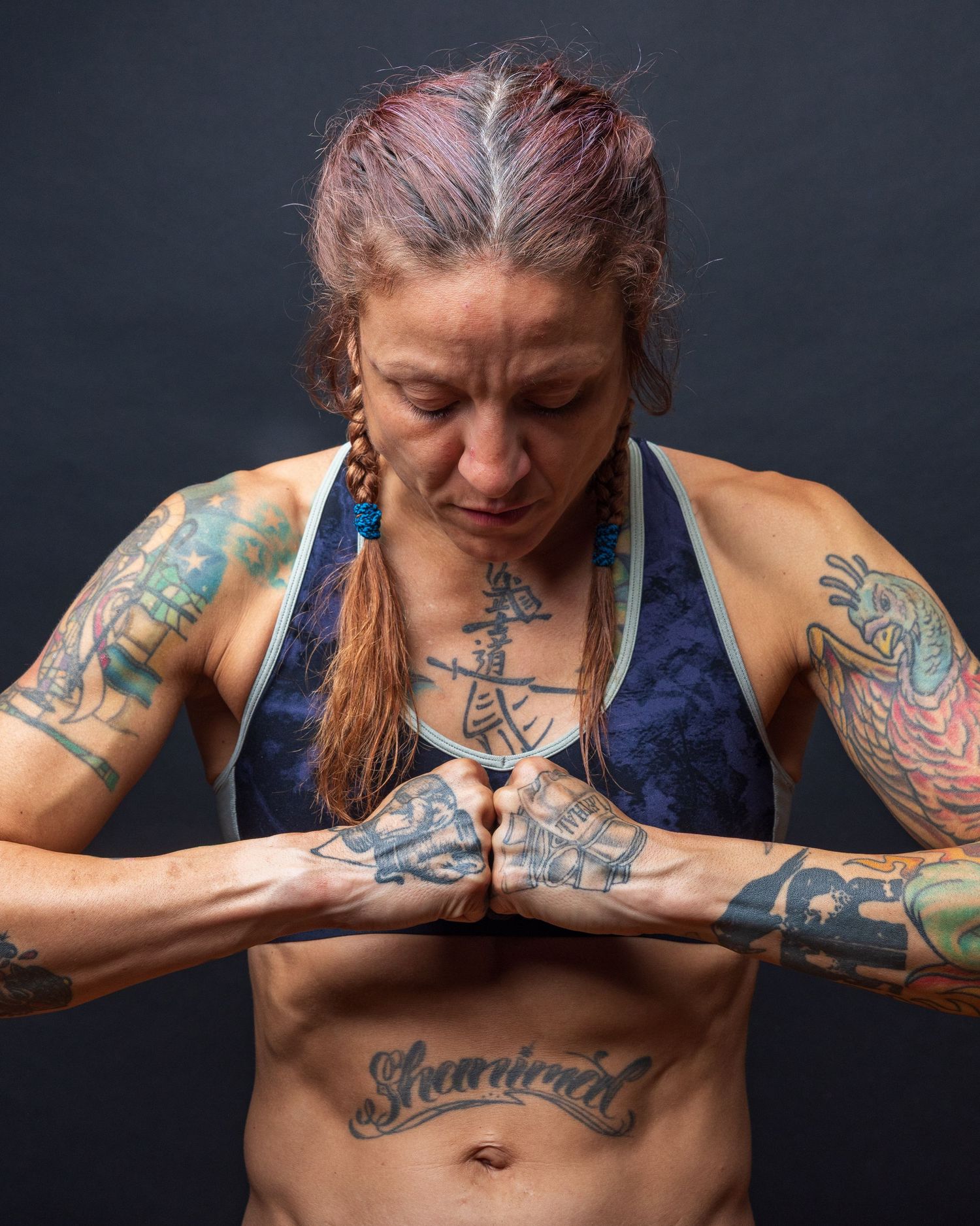 Artistic portrait series showing tattooed person in athletic pose against dark background. photography st louis