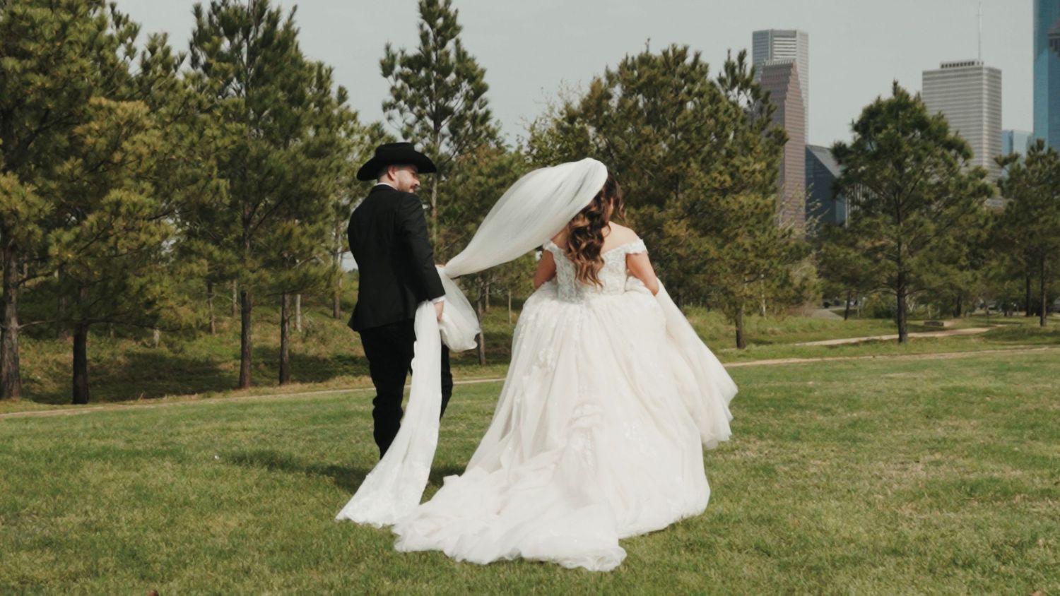 A couple in wedding attire shares intimate moments across a series of photos in a grassy outdoor setting with city views.