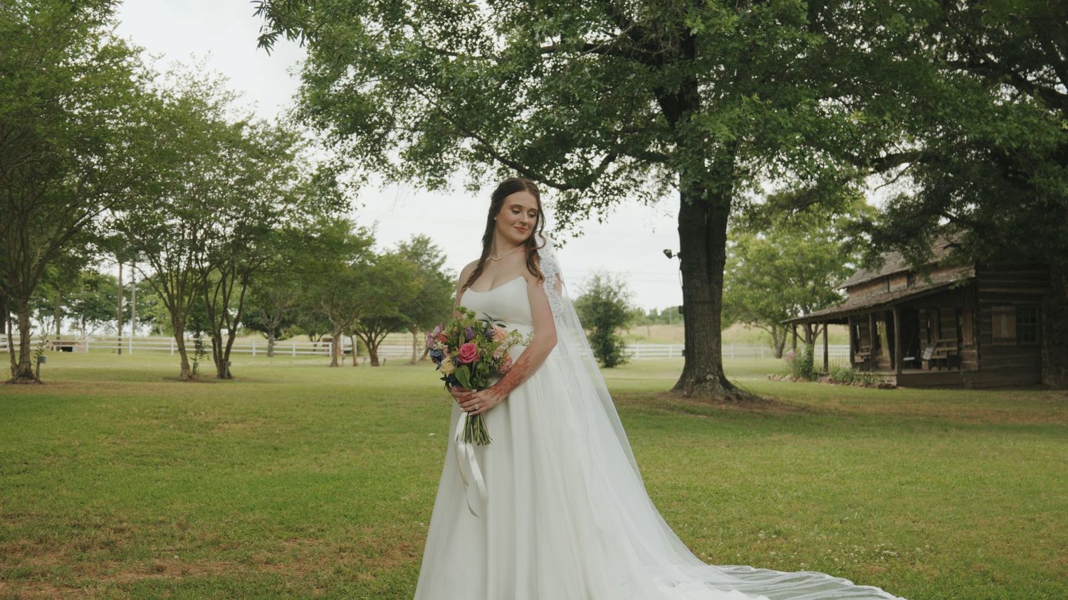 Scenic wedding venue on rolling green hills with trees in the background.