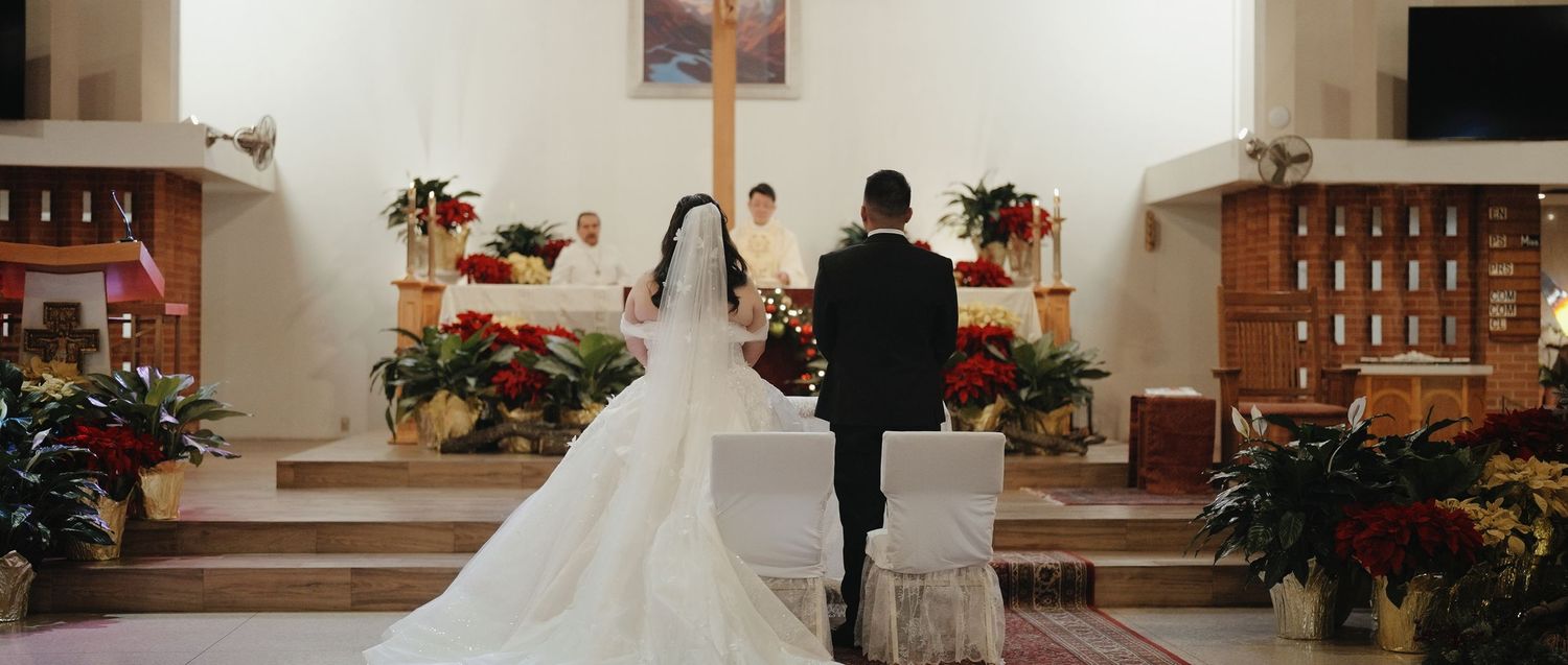 Wedding ceremony panorama showing church interior with wooden pews, floral arrangements and guests in formal attire.
