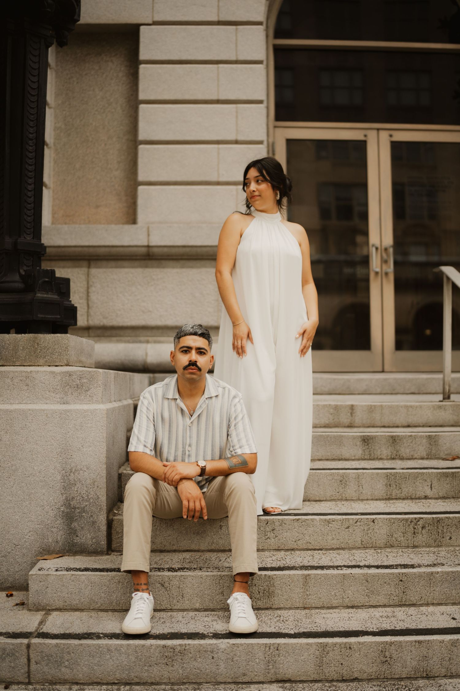 Artistic portrait series on concrete steps of a classical building exterior.