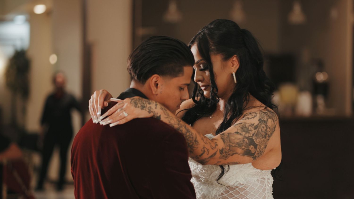 Romantic wedding couples share intimate moments and dances in a dimly lit reception venue.