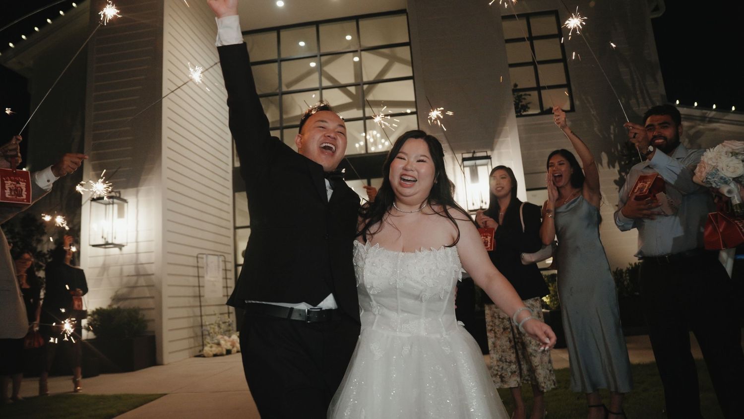 Couple shares their first dance as newlyweds at an indoor wedding reception with guests watching.