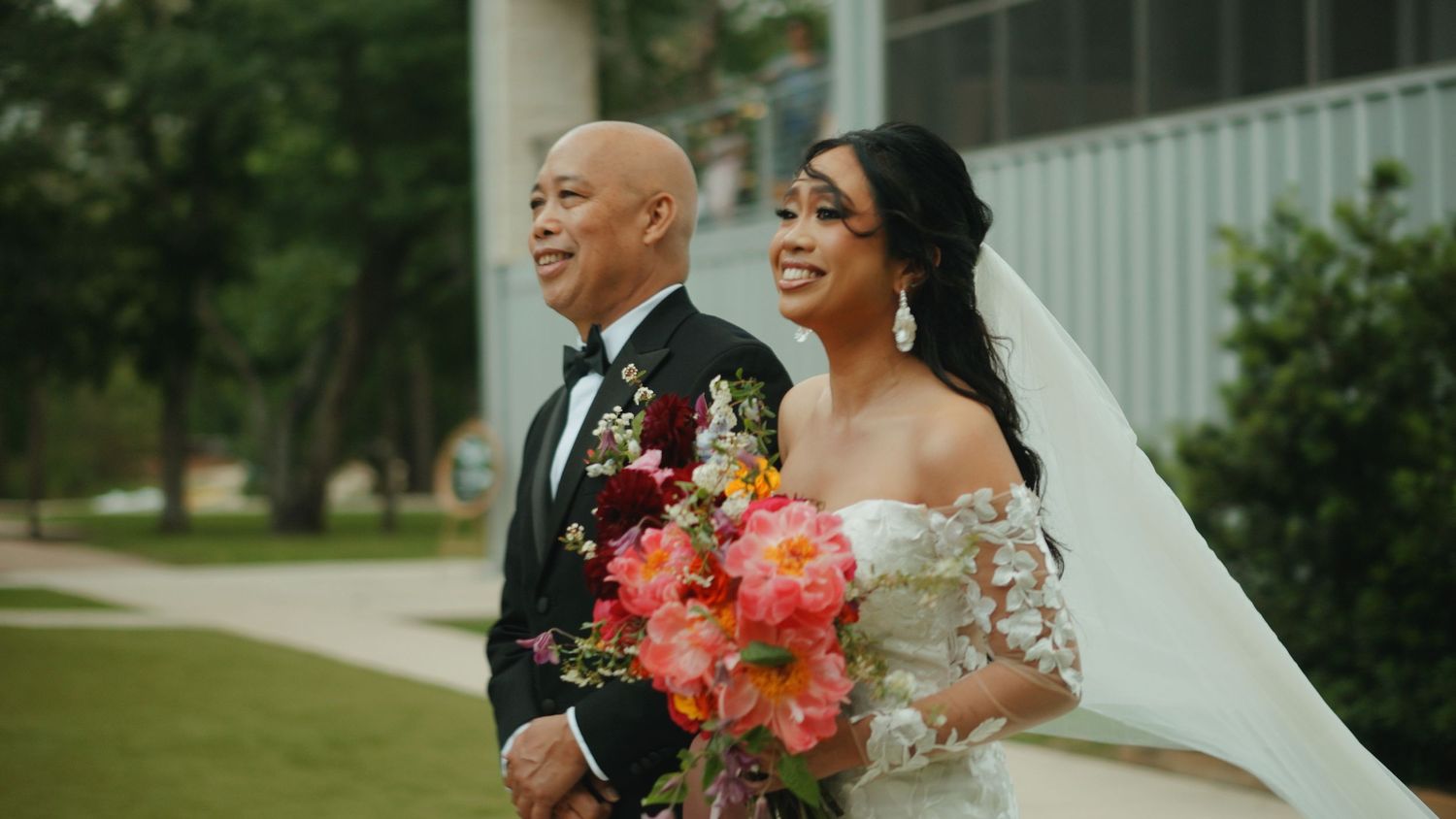 Wedding ceremony outdoors with colorful floral arrangements and natural greenery.