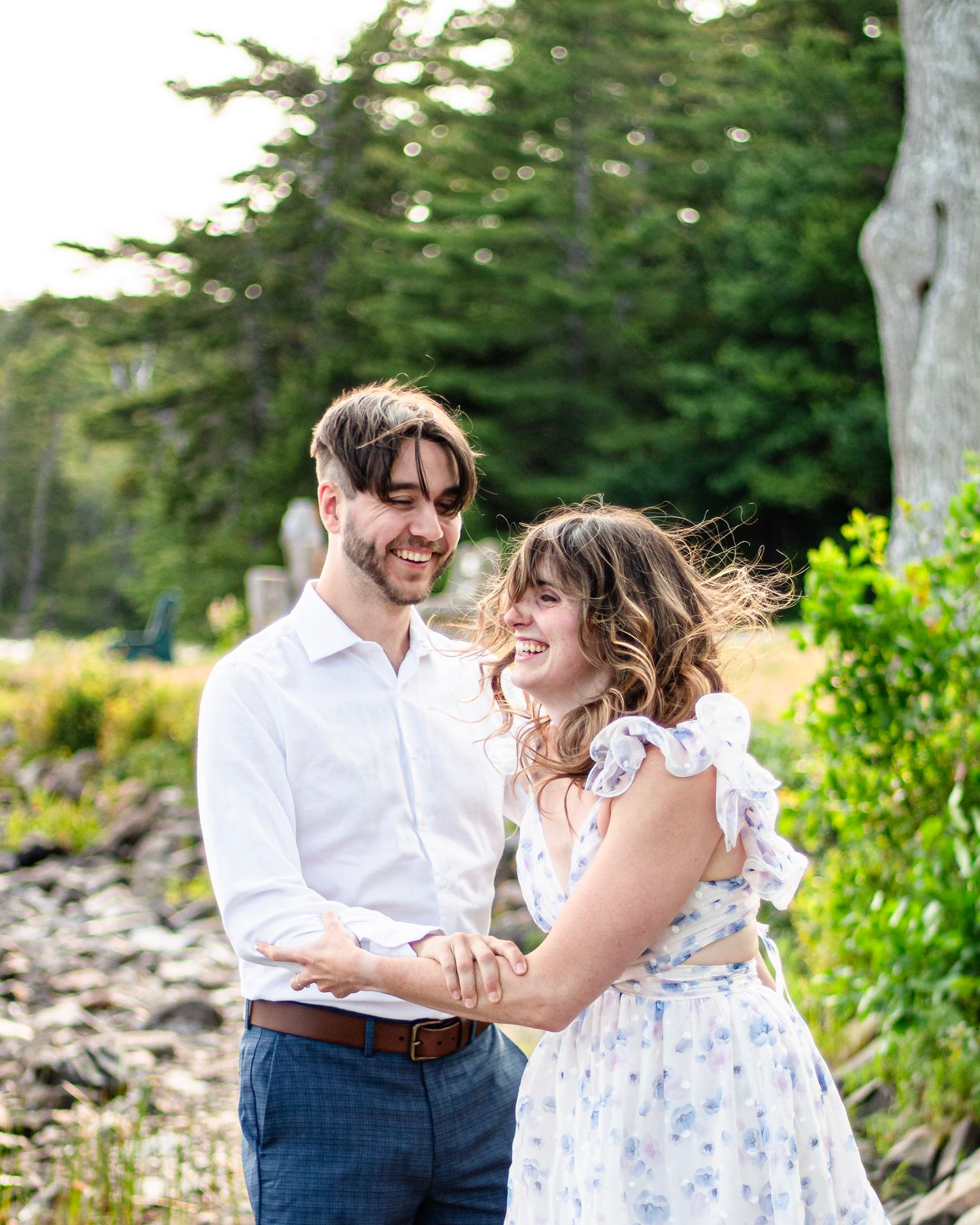 Young couple holding hands during outdoor lifestyle session, Candid couple laughing together during portrait session