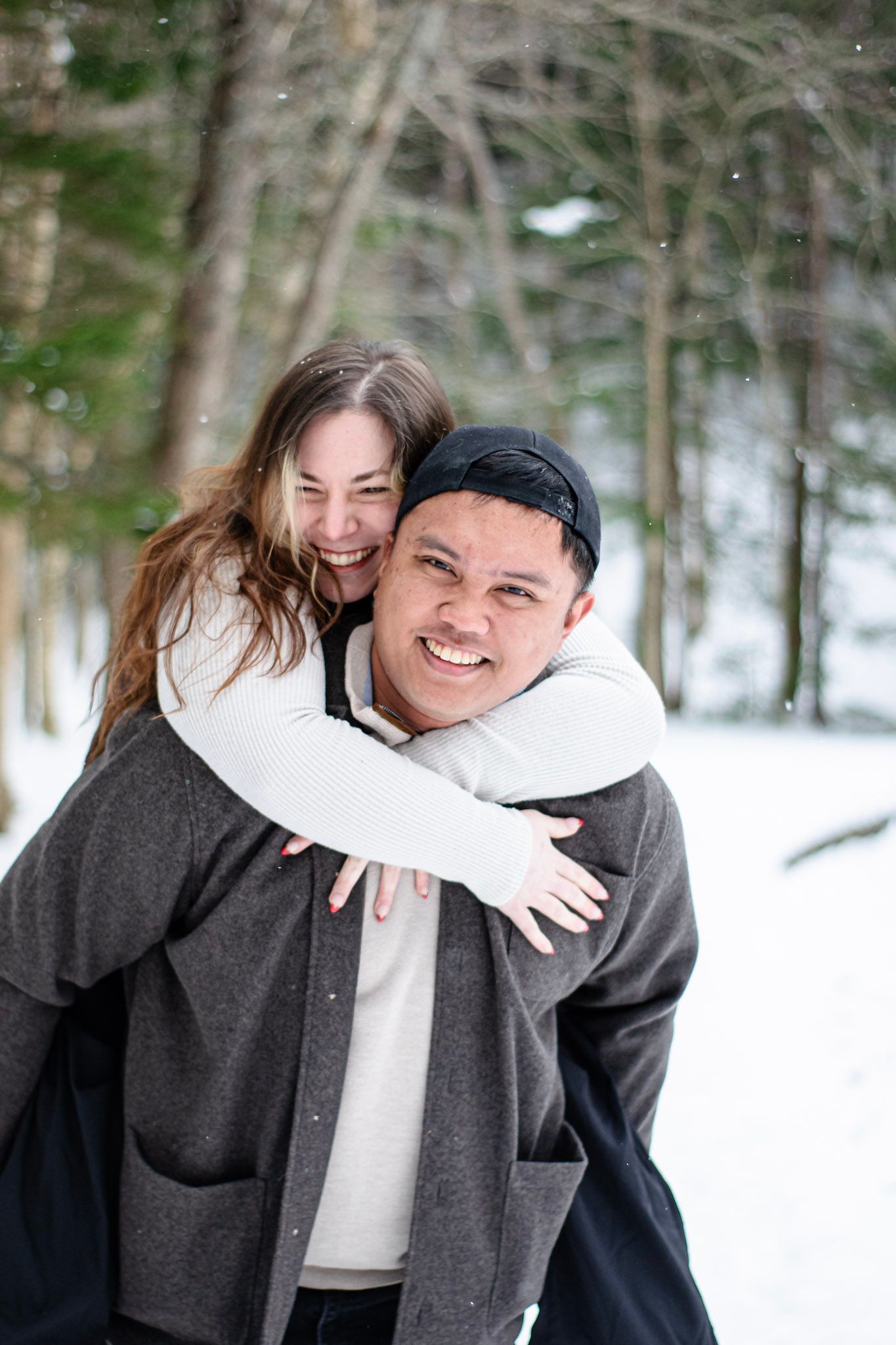 Young couple holding hands during outdoor lifestyle session, Candid couple laughing together during winter mini session
