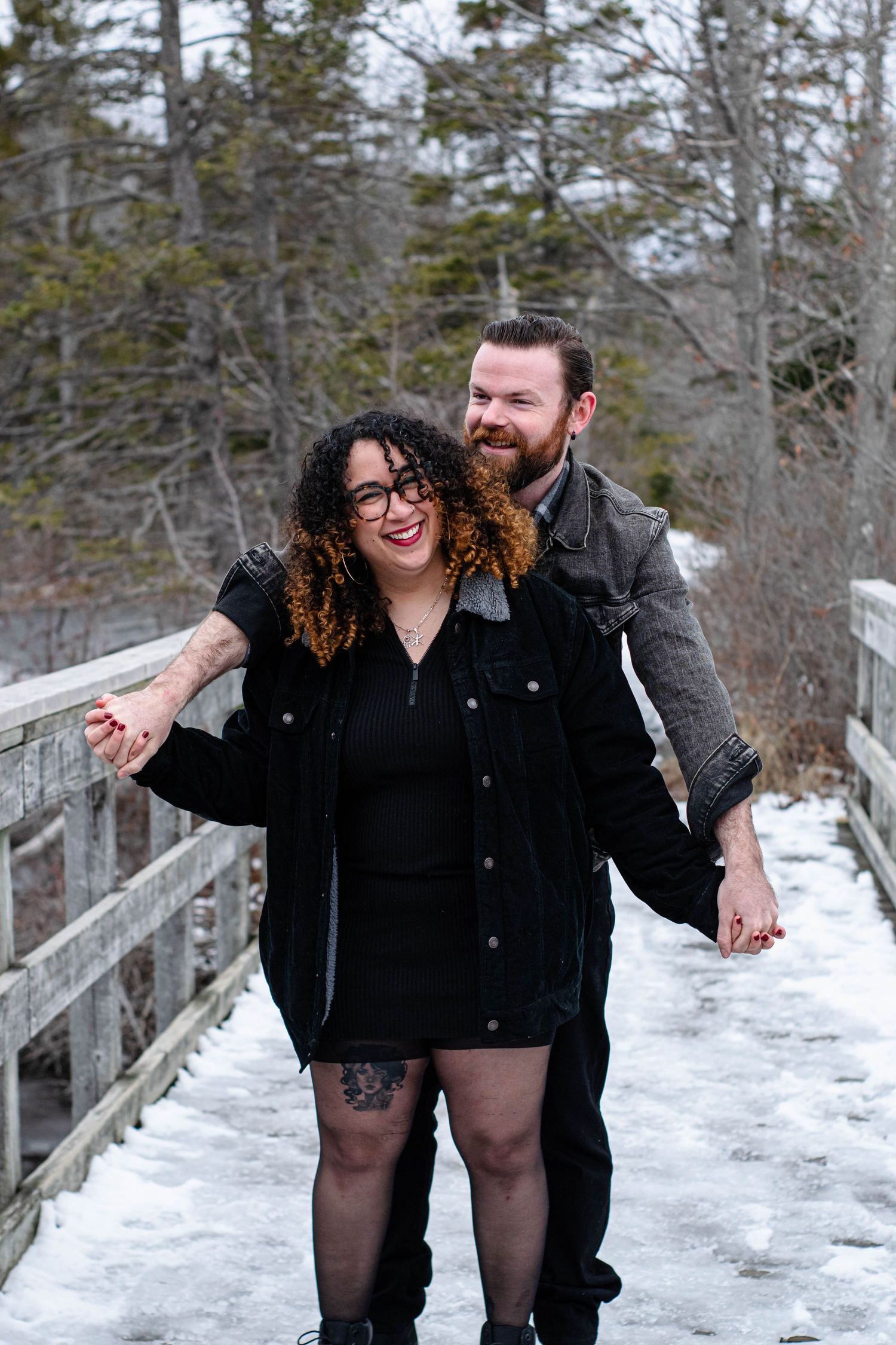 Young couple holding hands during outdoor lifestyle session, Candid couple laughing together during winter mini session