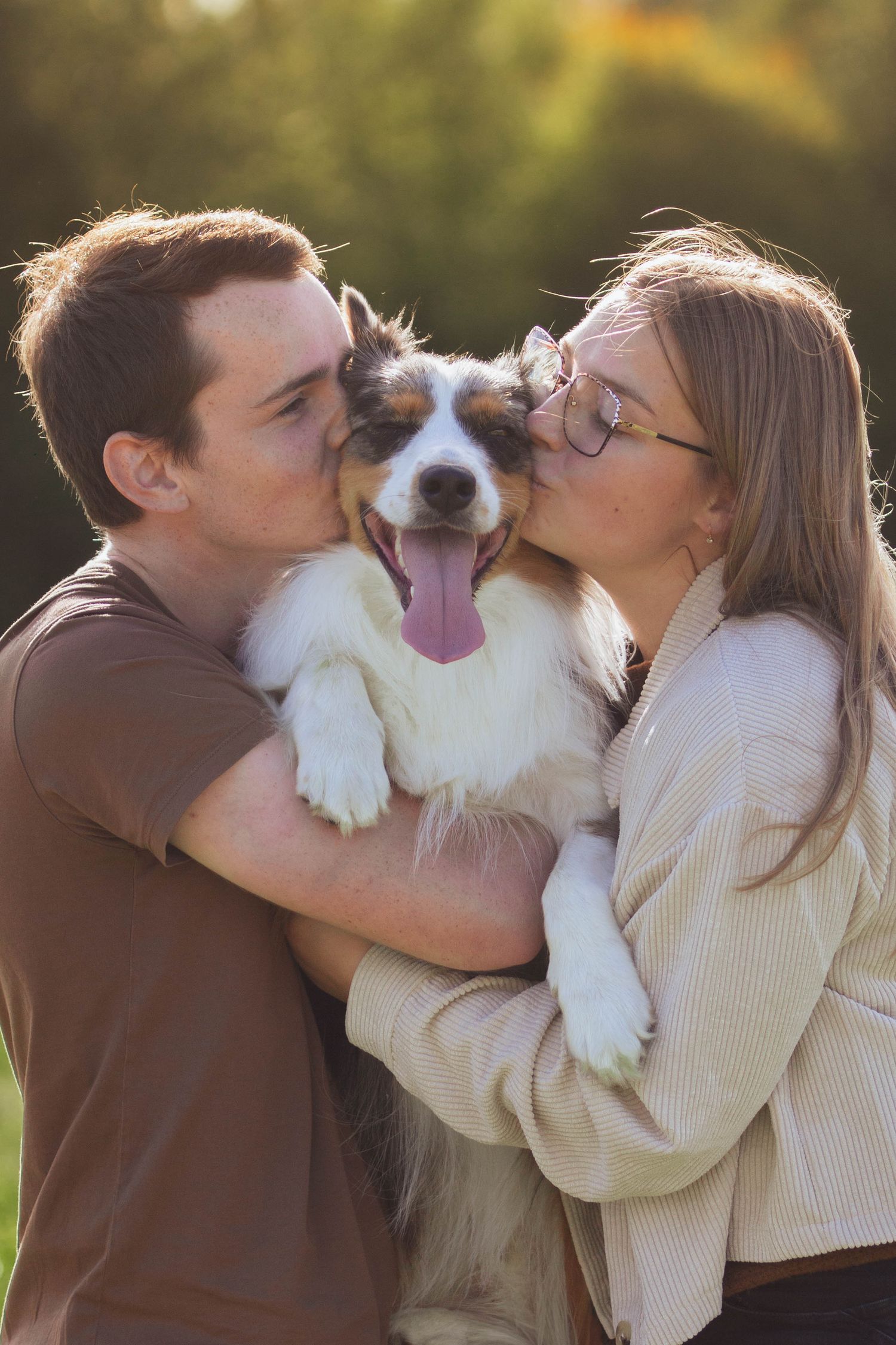 Jeune couple embrassent leur chien berger australien