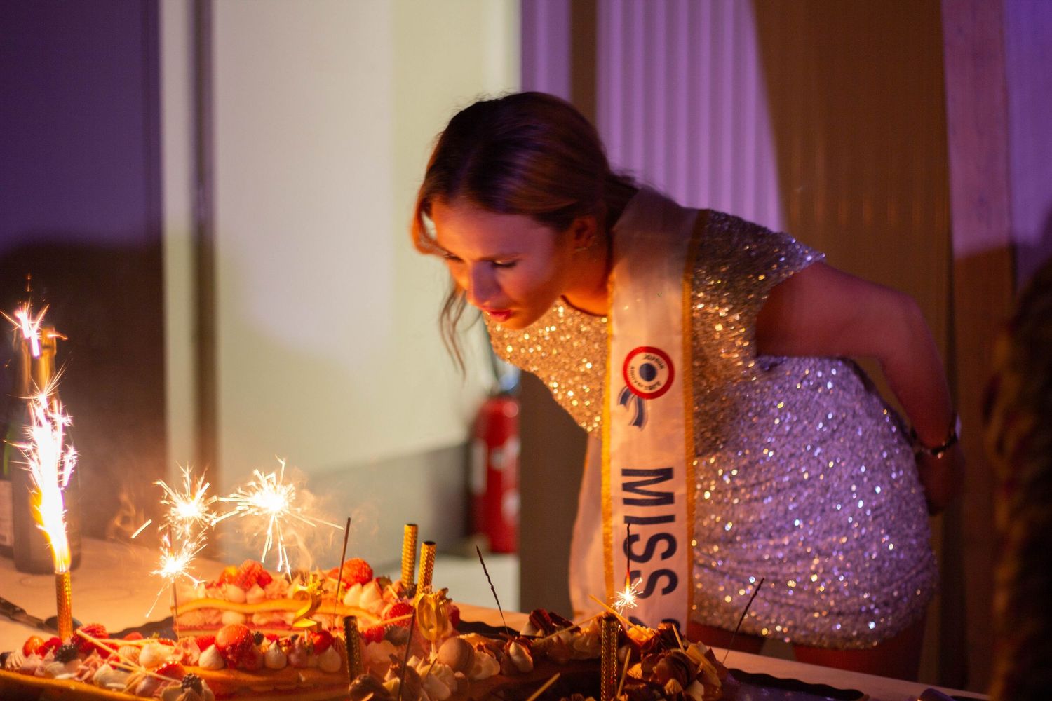 Jeune femme fête ses 20 ans et souffle ses bougies