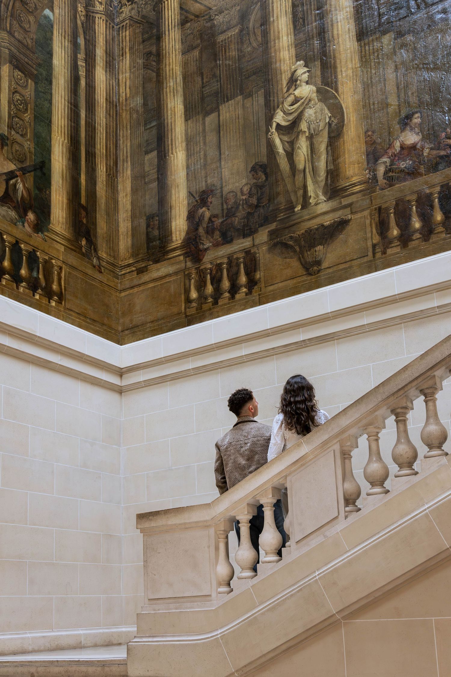 Jeune couple dans un musée qui regarde un tableau.