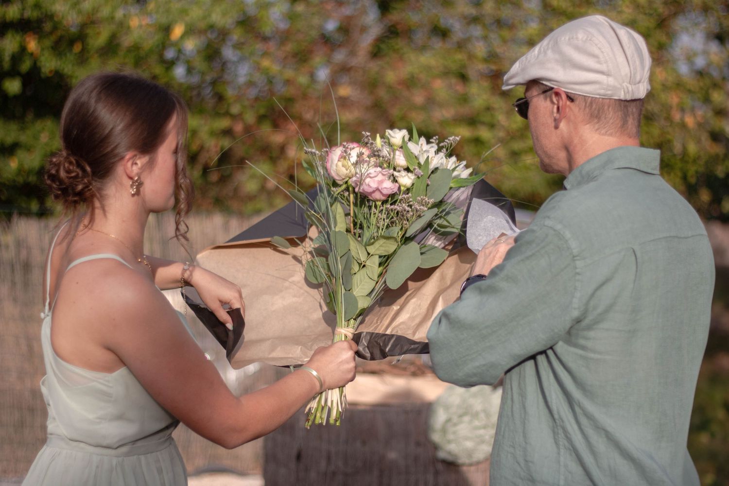 Une femme et son papa son de dos et déballe un bouquet de fleur