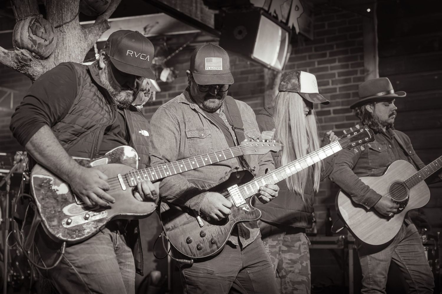 Black and white panorama of musicians playing various string instruments on stage. Grand Union Spooks on Spurr