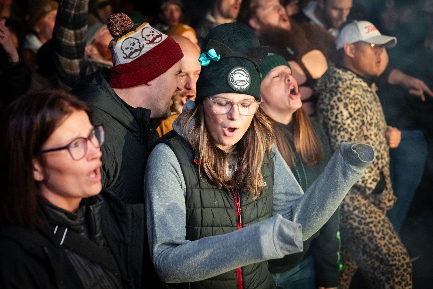 Enthusiastic crowd members cheering and reacting during a live performance.