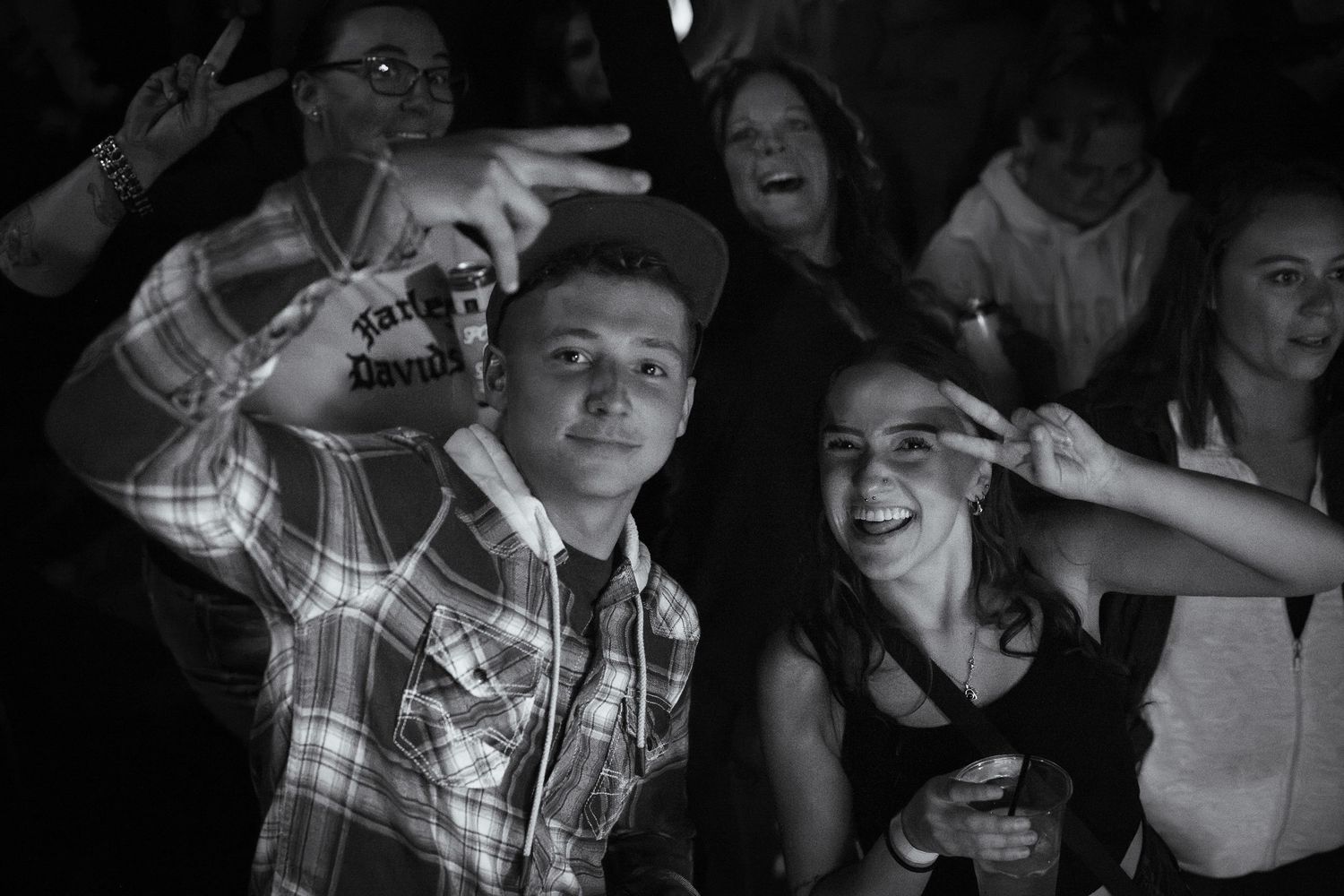 Energetic crowd reactions captured in black and white at a live music event.
