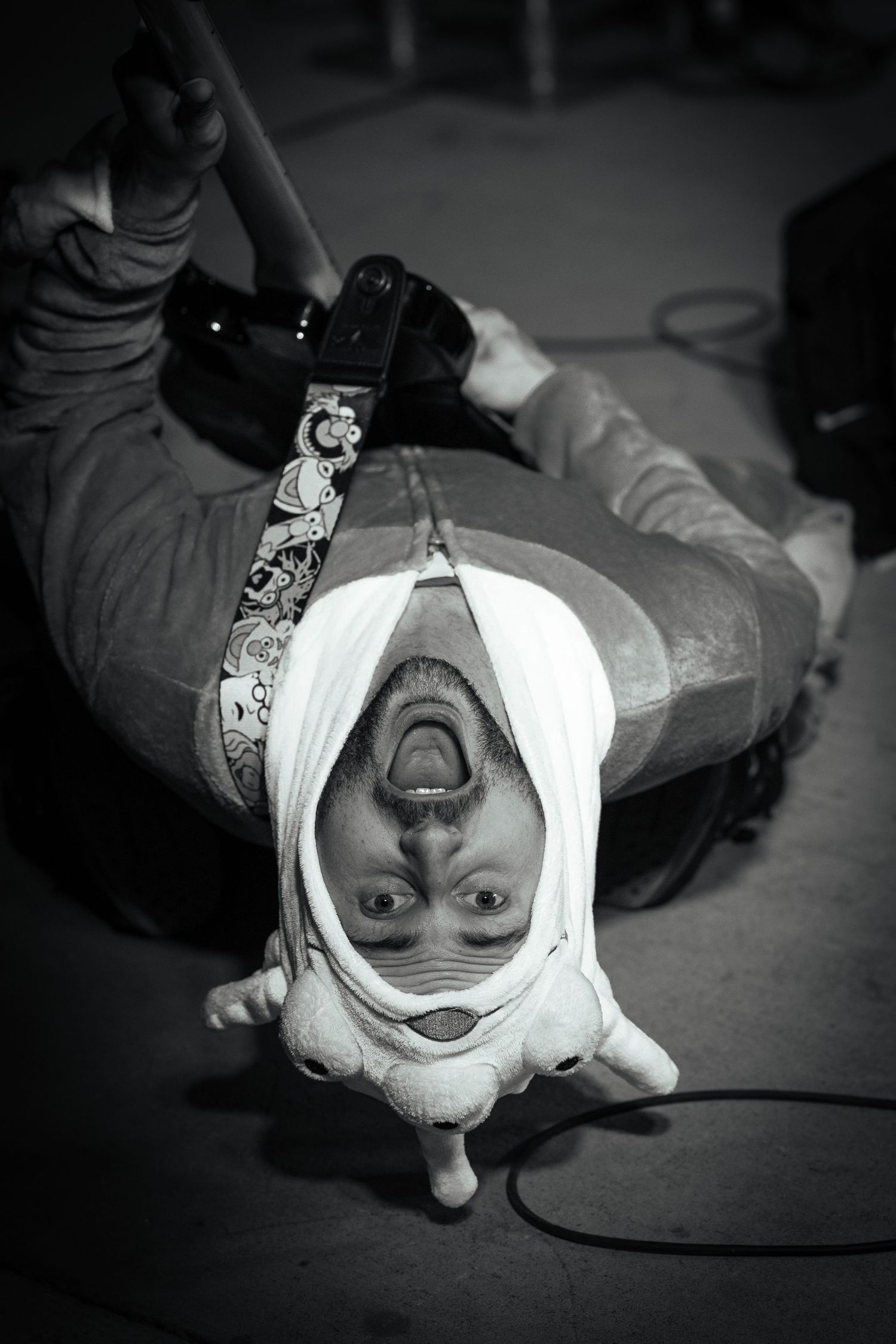 Black and white sequence showing an upside down performer in white face paint making expressive faces. Wet Possum band