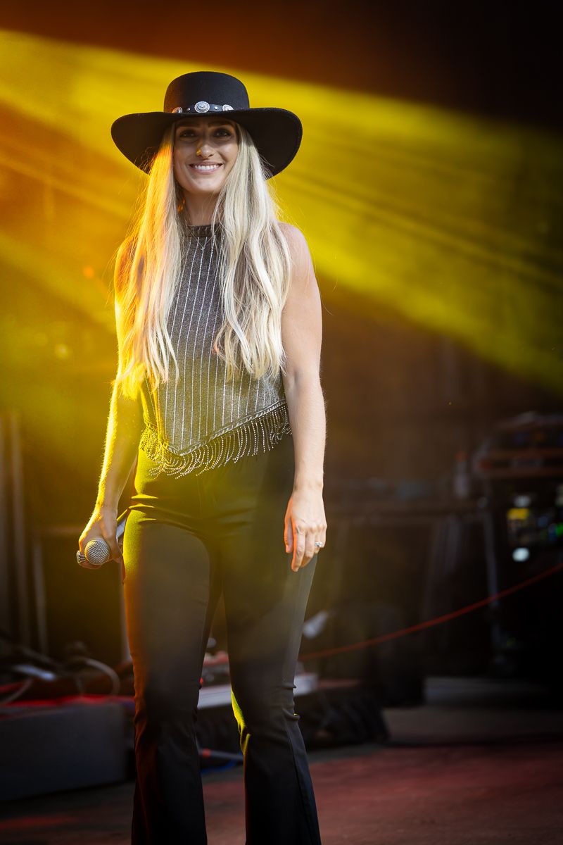 Performer in black outfit and hat on stage with dramatic yellow spotlight. Grand Union