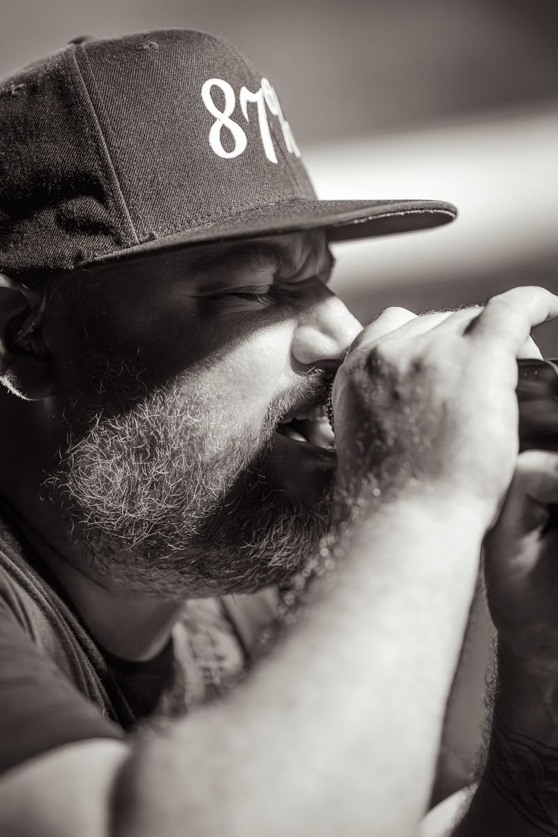 Close-up black and white profile shot of person wearing baseball cap. Grand Union.