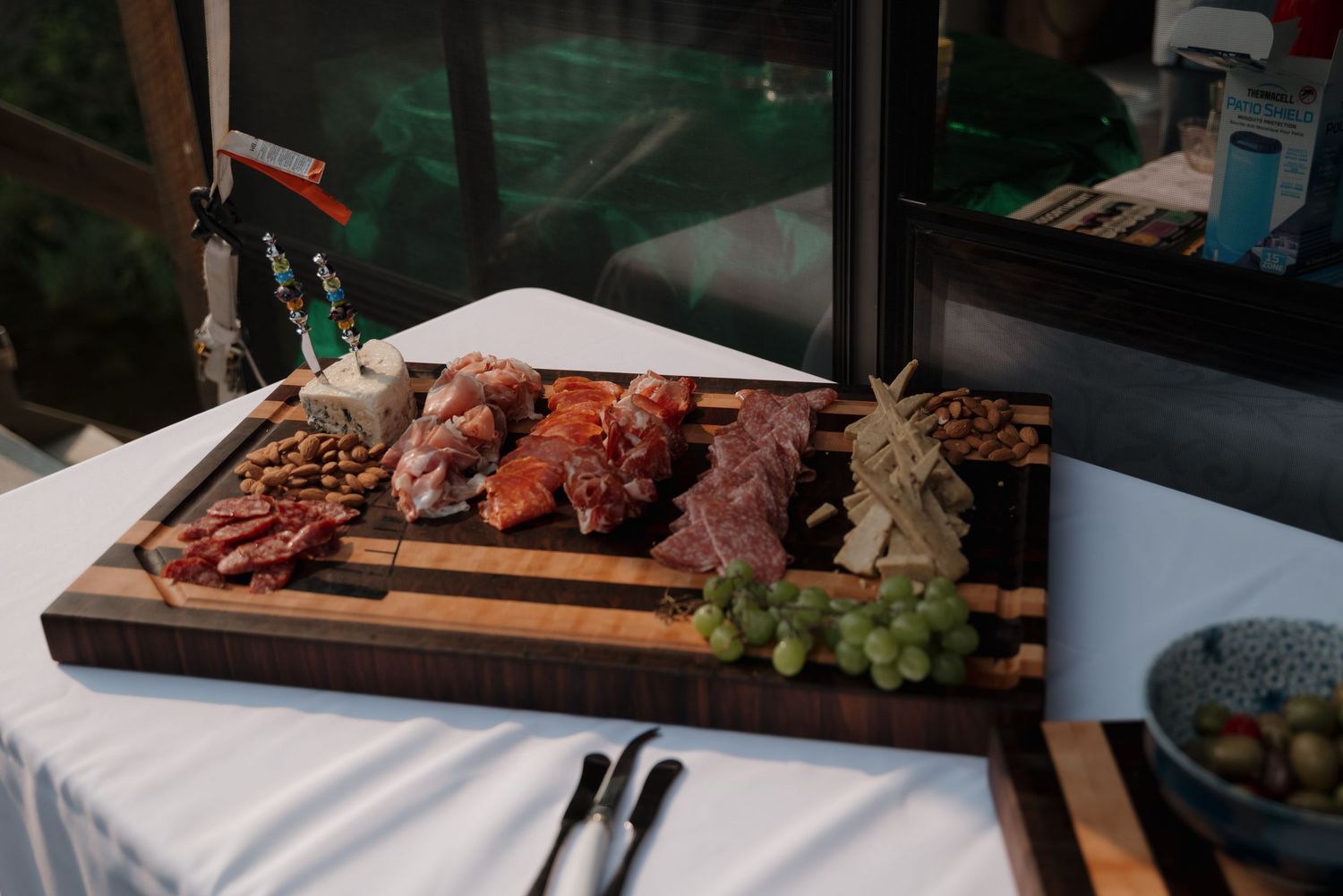 Charcuterie board display with meats, cheeses, and fruits arranged on wooden serving platters.