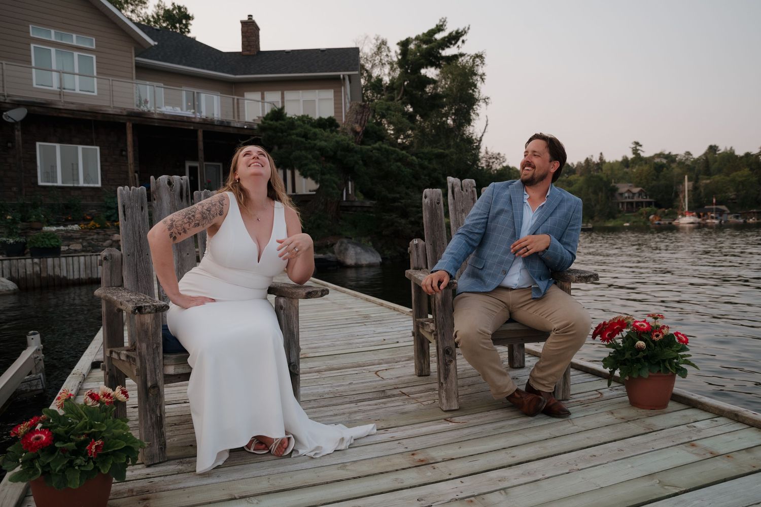 Couple dancing together on a wooden dock by the water during sunset at a lakeside celebration.