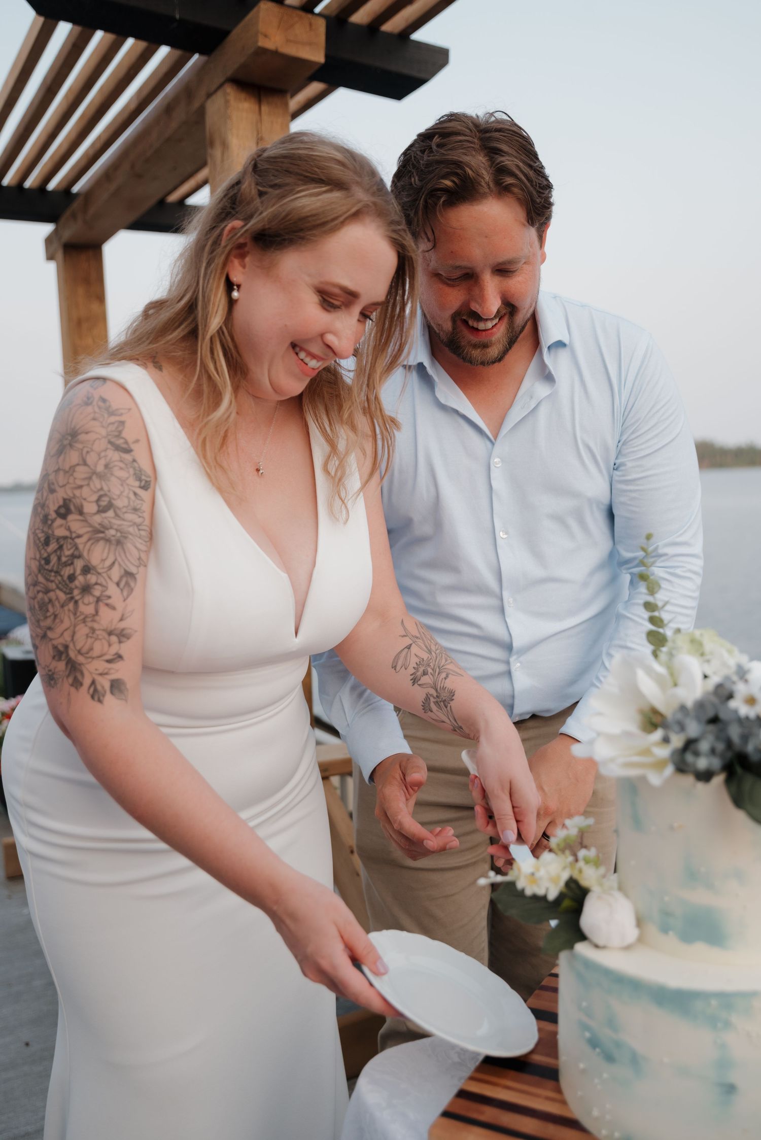 A couple cuts into their light blue and white wedding cake together during their reception.