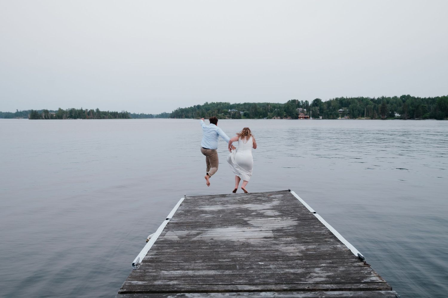 A wooden platform extends over calm waters with distant shoreline visible.