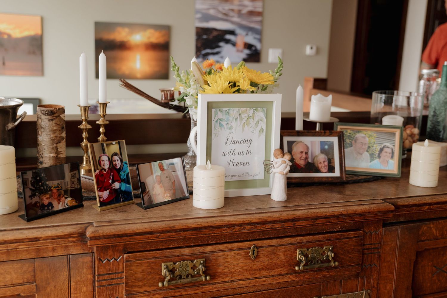 Rustic wooden bar counter with vintage decor and framed photos displayed on shelves.