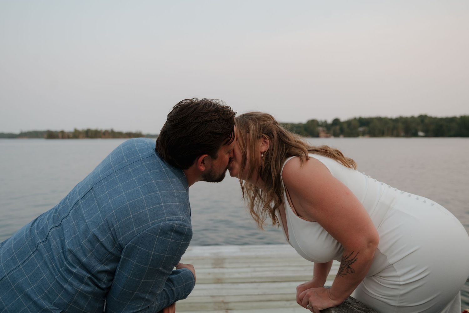 Romantic couple sharing an intimate moment at sunset by the lake.