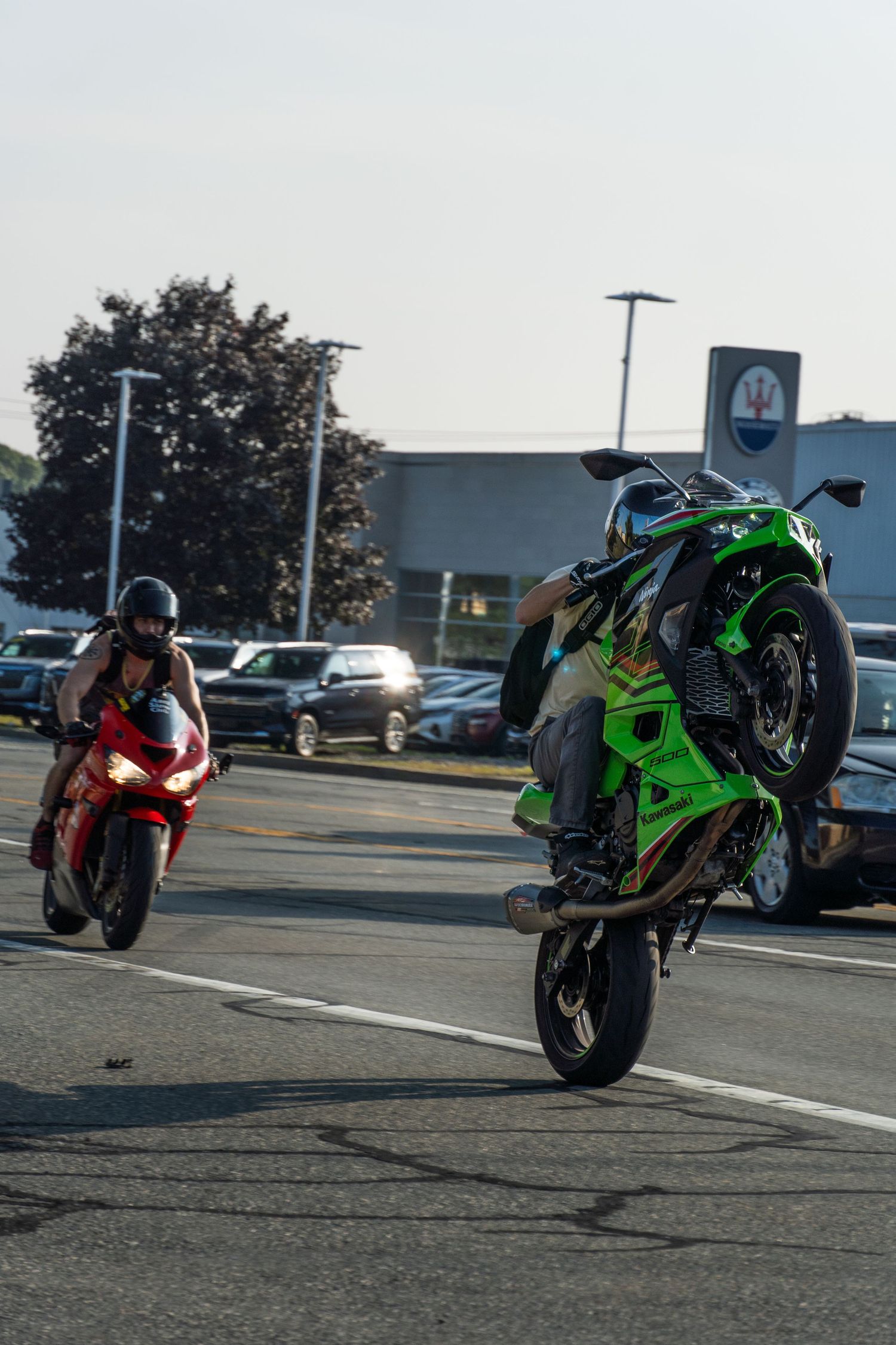 Green Kawasaki Ninja 500 doing a wheelie