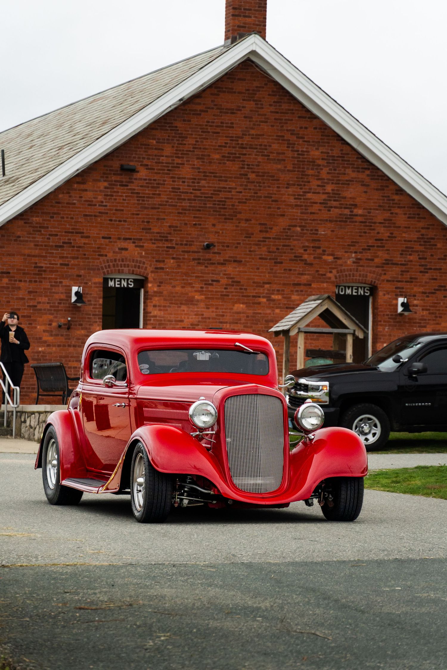 Older Red car pulling up for cars and coffee