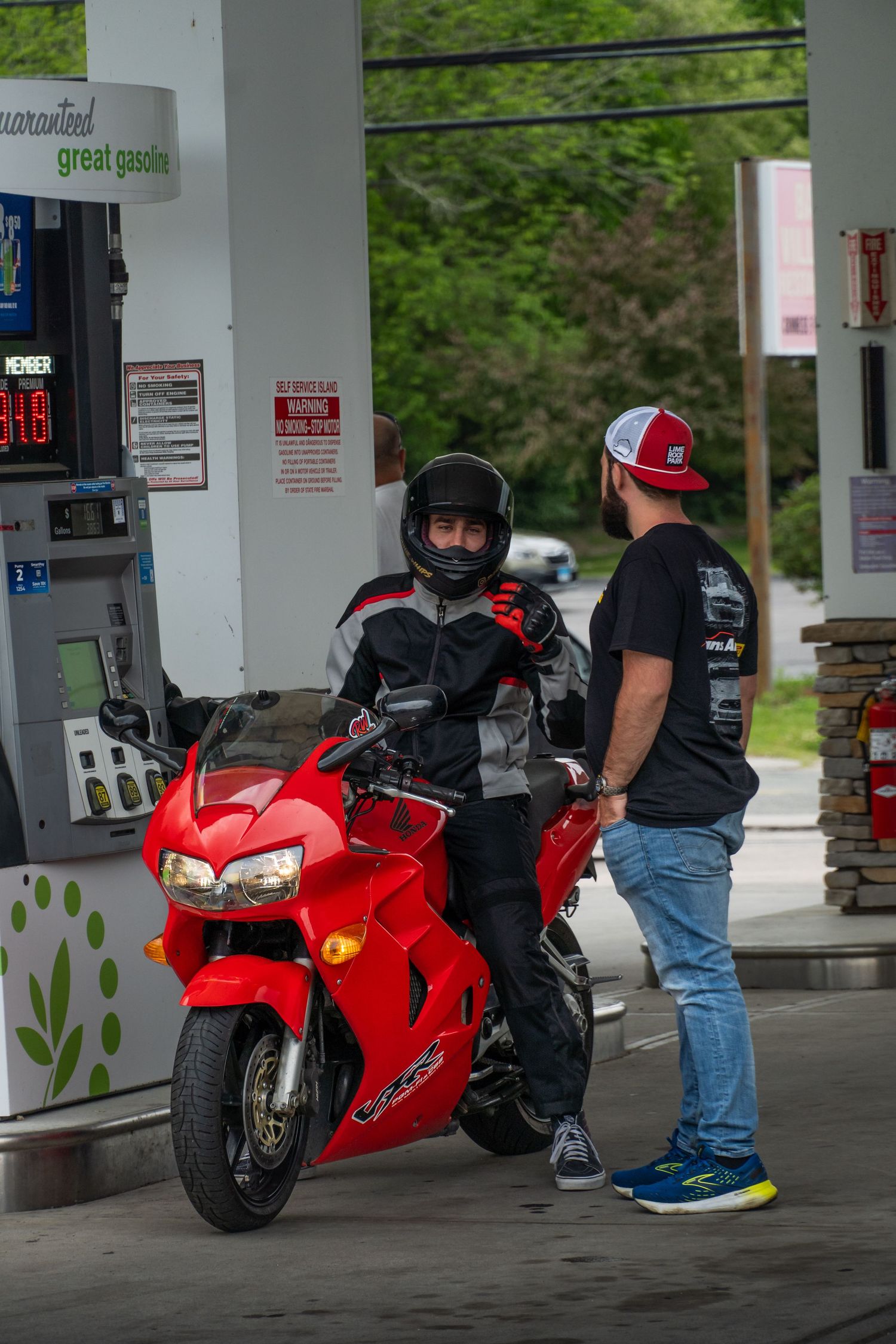 Honda VFR800 getting gas and talking to a friend