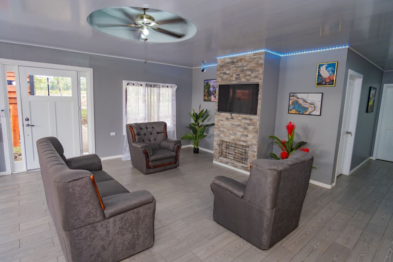 Contemporary lounge area with gray armchairs and stone accent wall details.