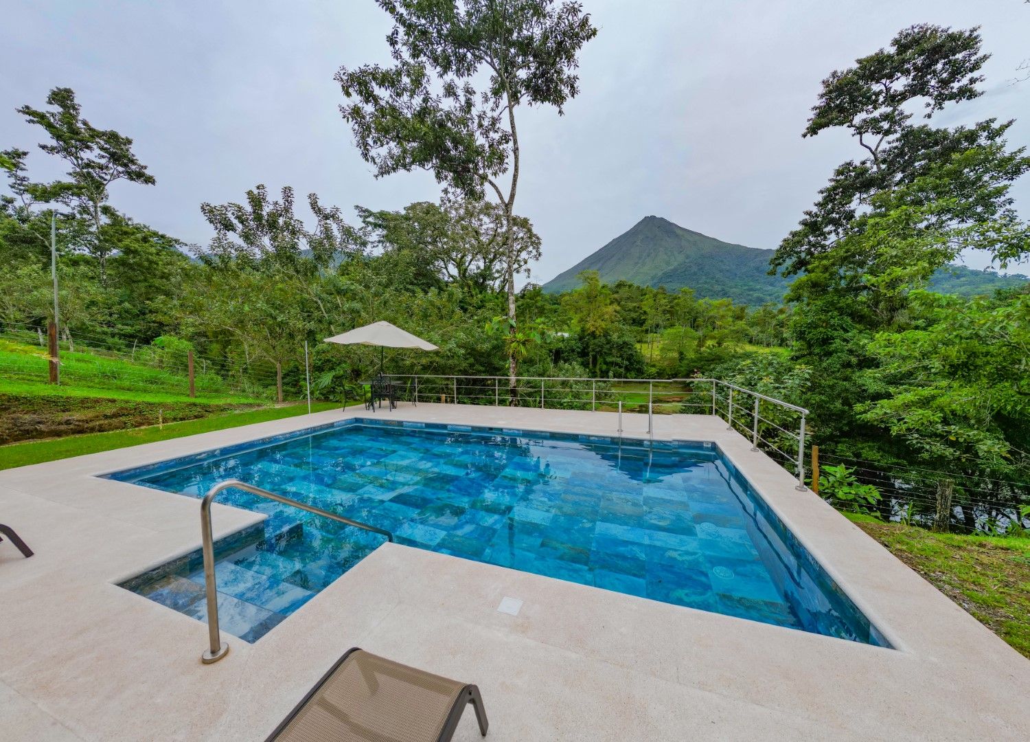 Luxury infinity pool overlooking lush mountain landscape and tropical scenery.