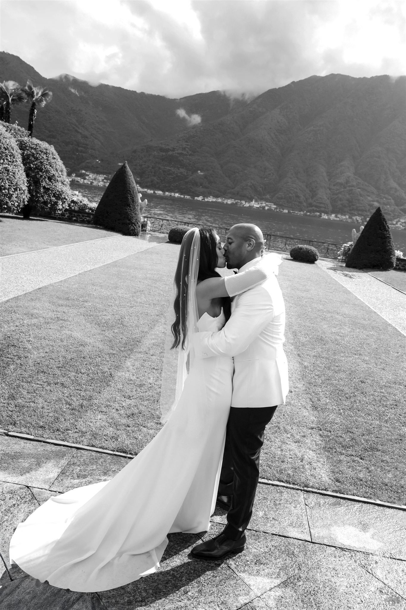 Black and white wedding portraits capture dancing moments in an elegant outdoor setting.