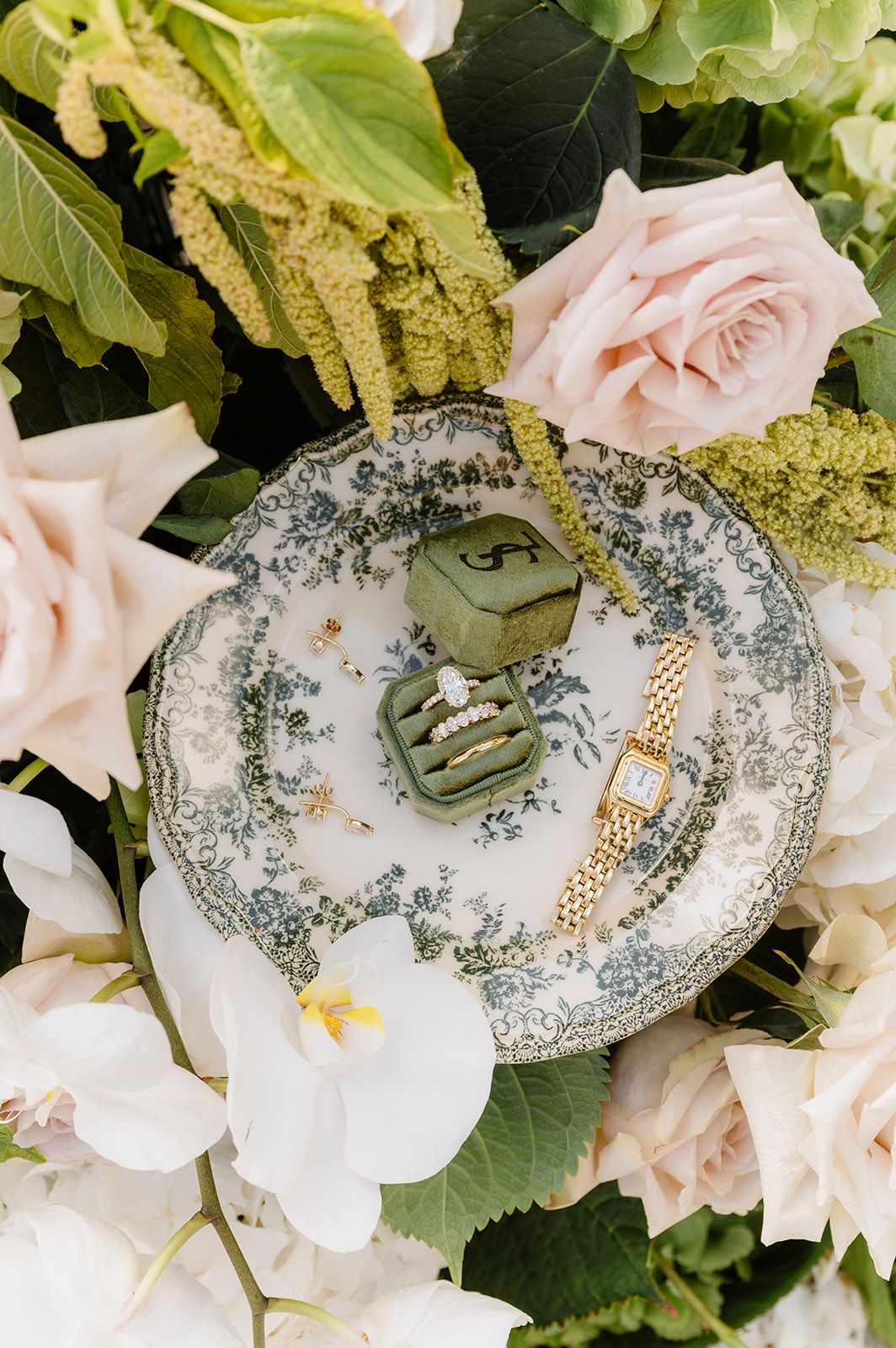 Delicate floral arrangement with pink roses and vintage china pattern details.
