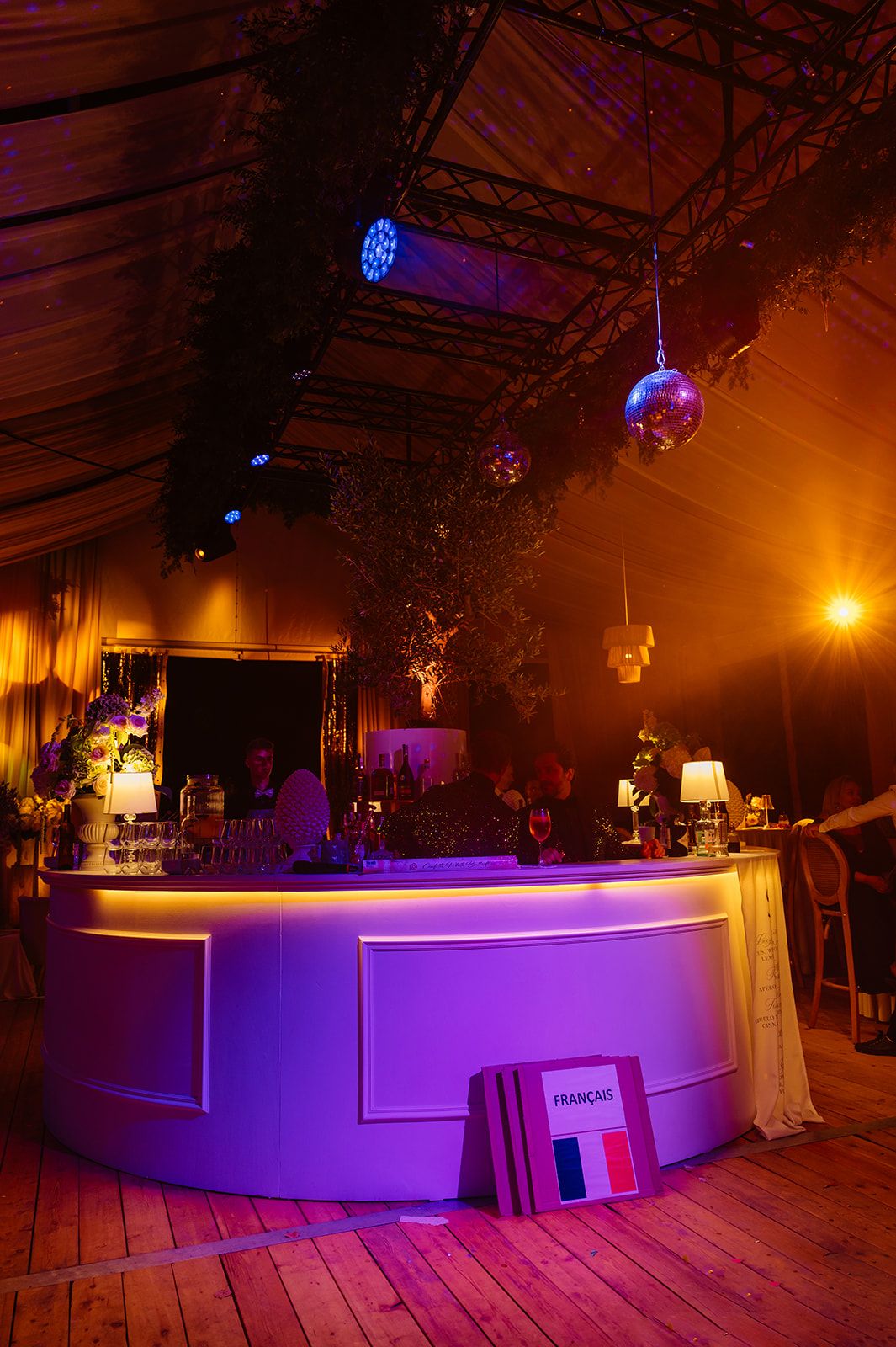 Purple-lit modern bar setup at an elegant wedding reception venue.