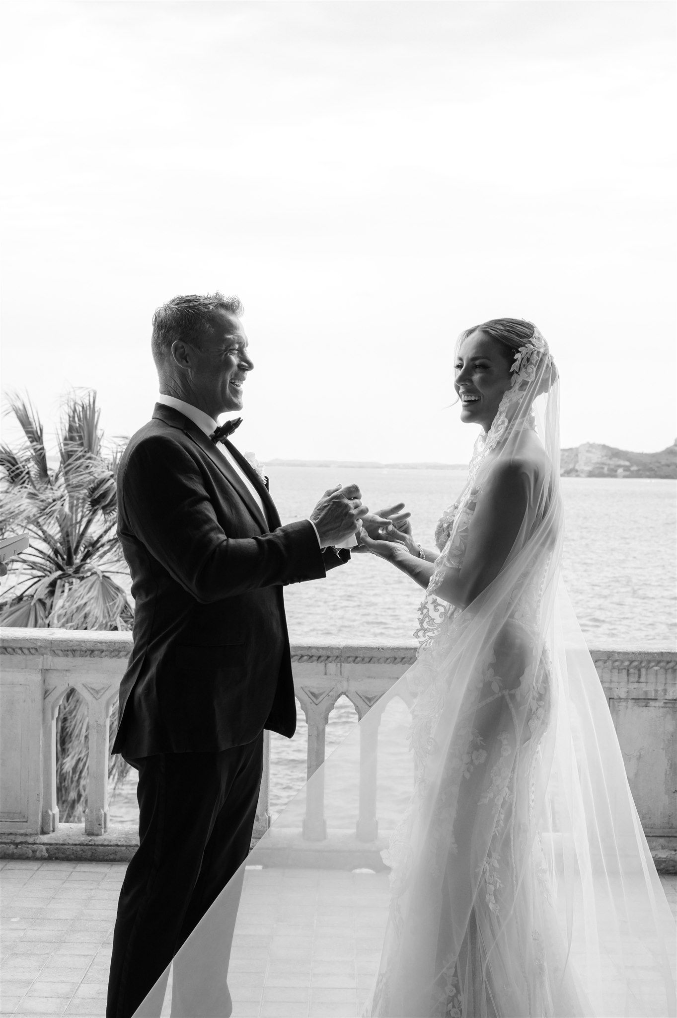 Seaside wedding ceremony with elegant columns and ocean view in the background.