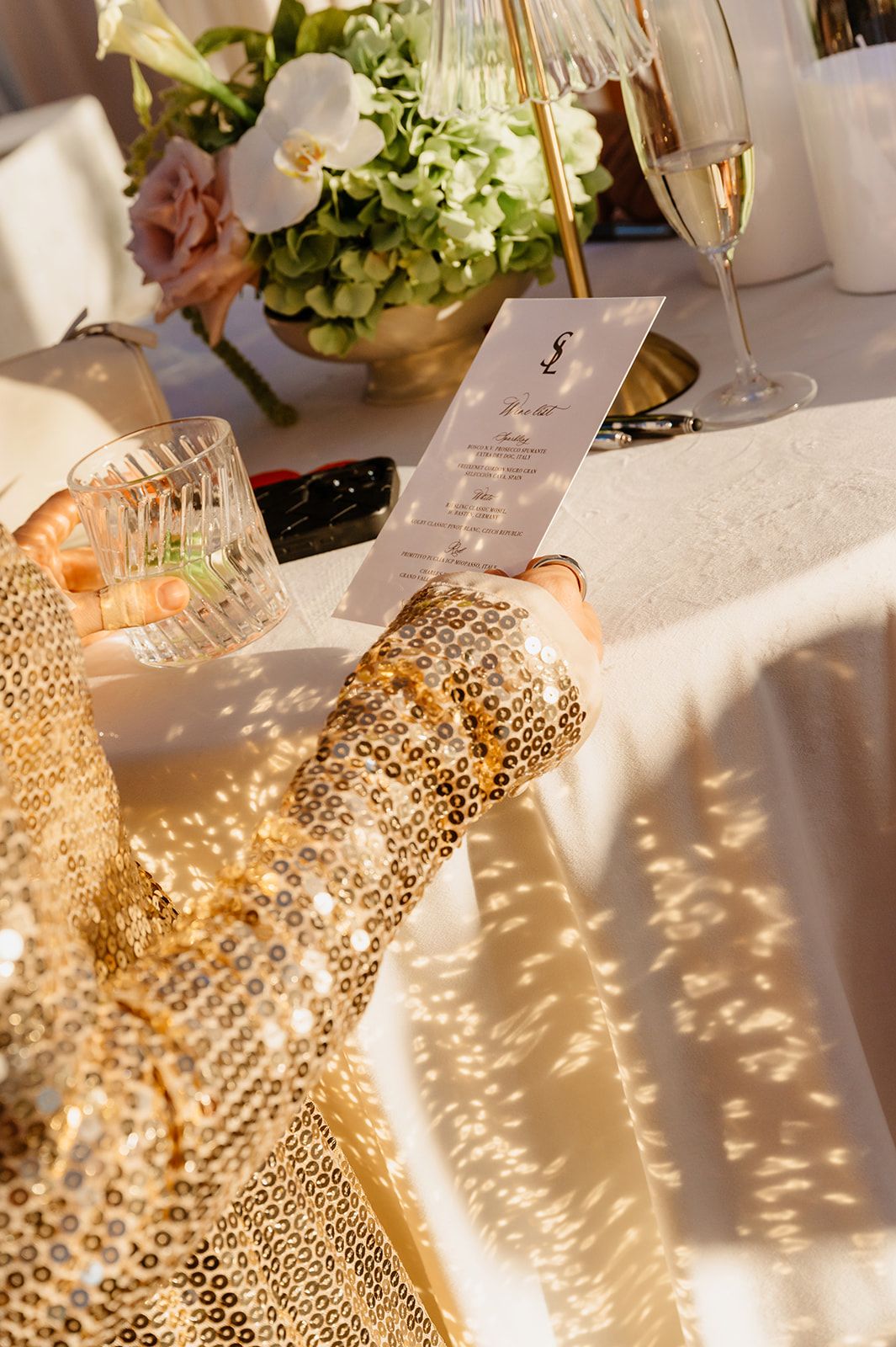 Decorative light patterns casting shadows on white tablecloth at wedding reception.