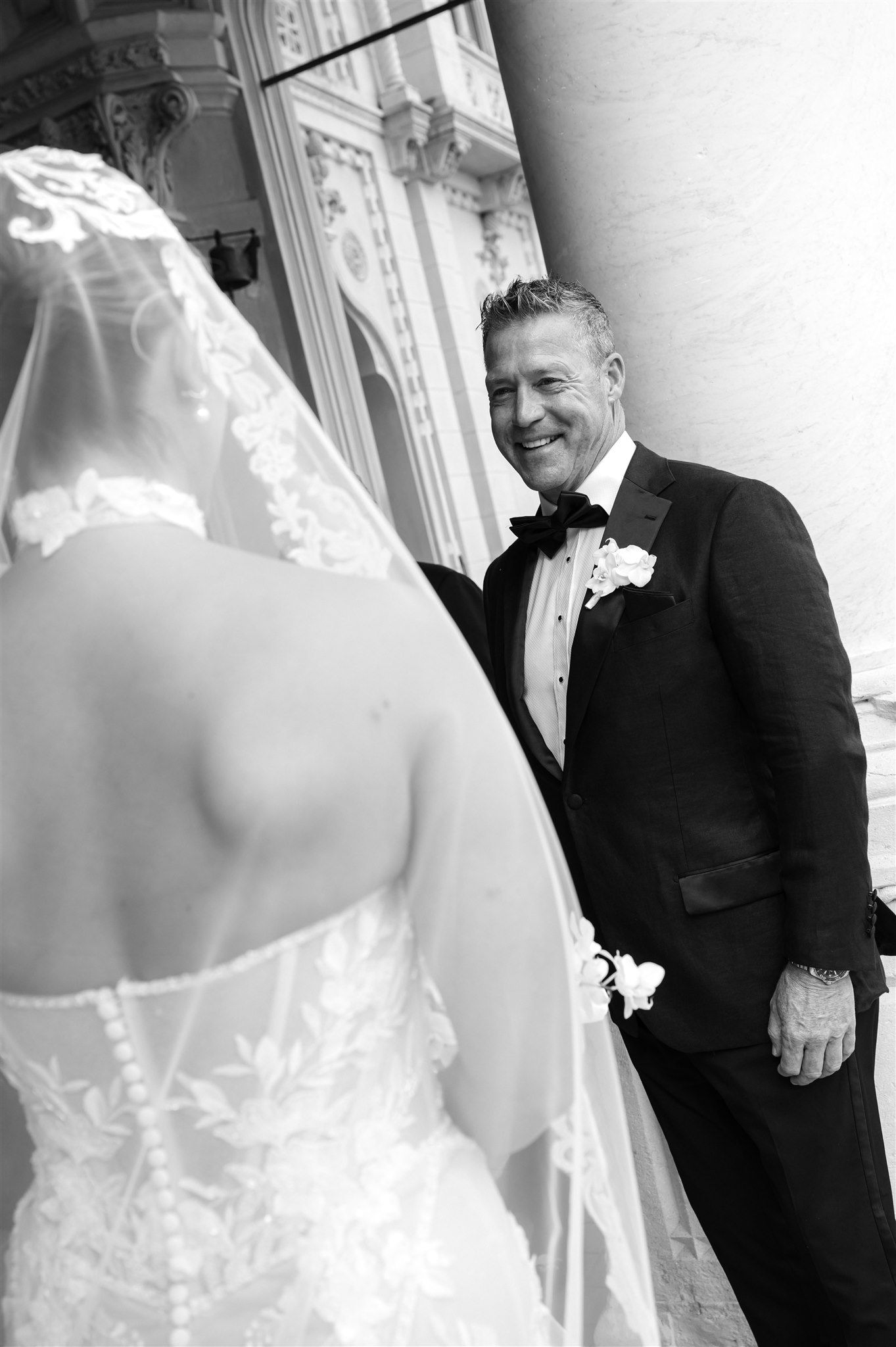 Wedding moment captured in black and white showing elegant bridal gown details.