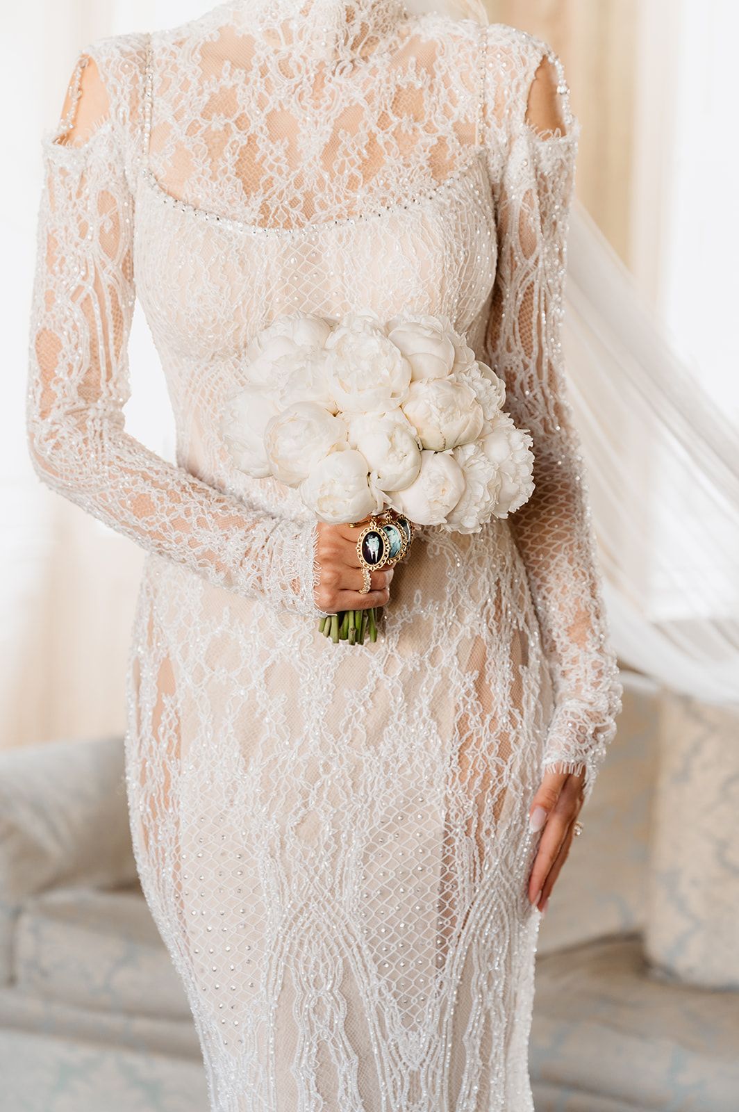 Close-up details of intricate lace wedding dress with delicate beading and embellishments.