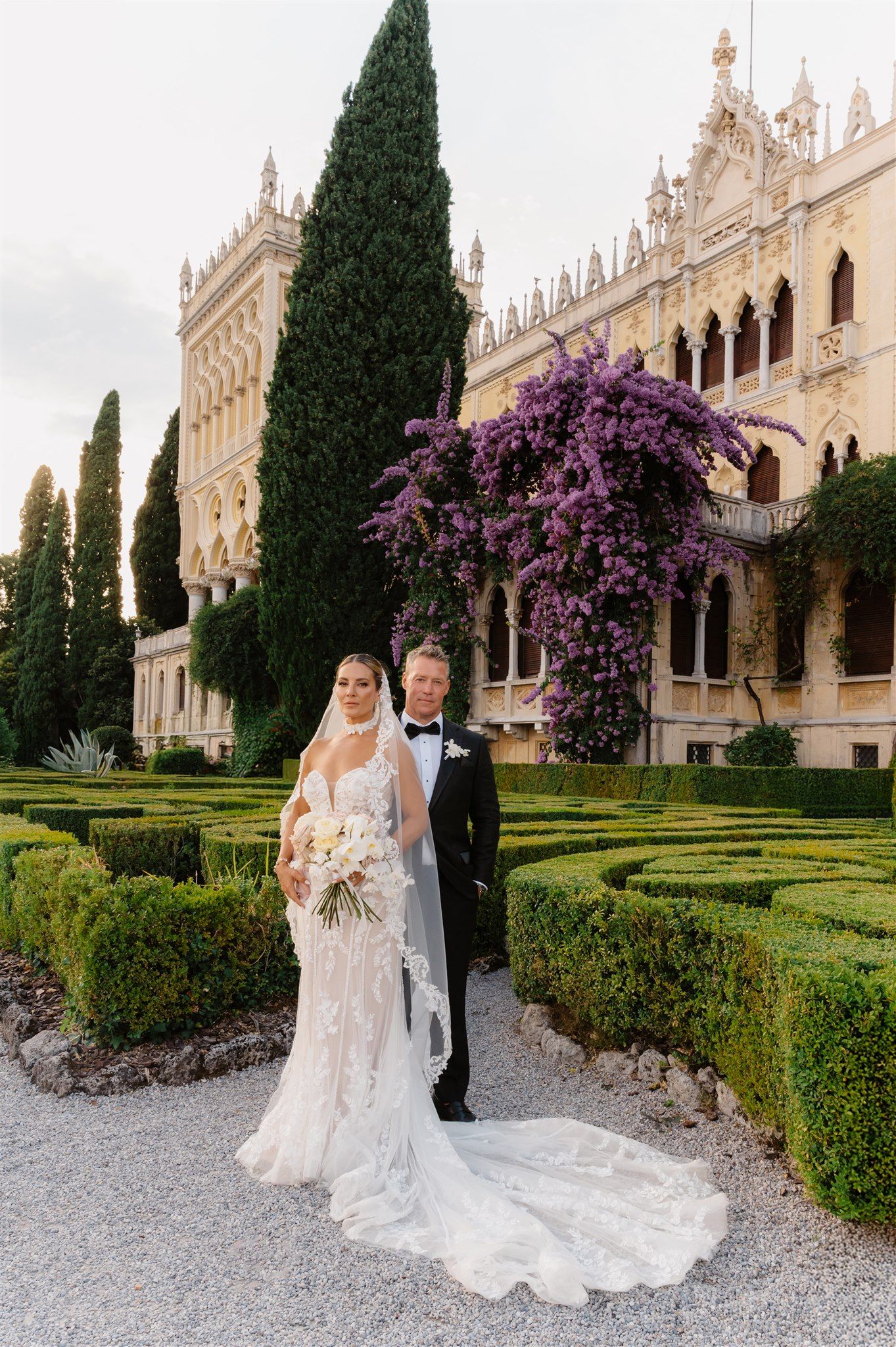 Elegant garden wedding venue with purple flowering vines and manicured hedges in Isola del Garda