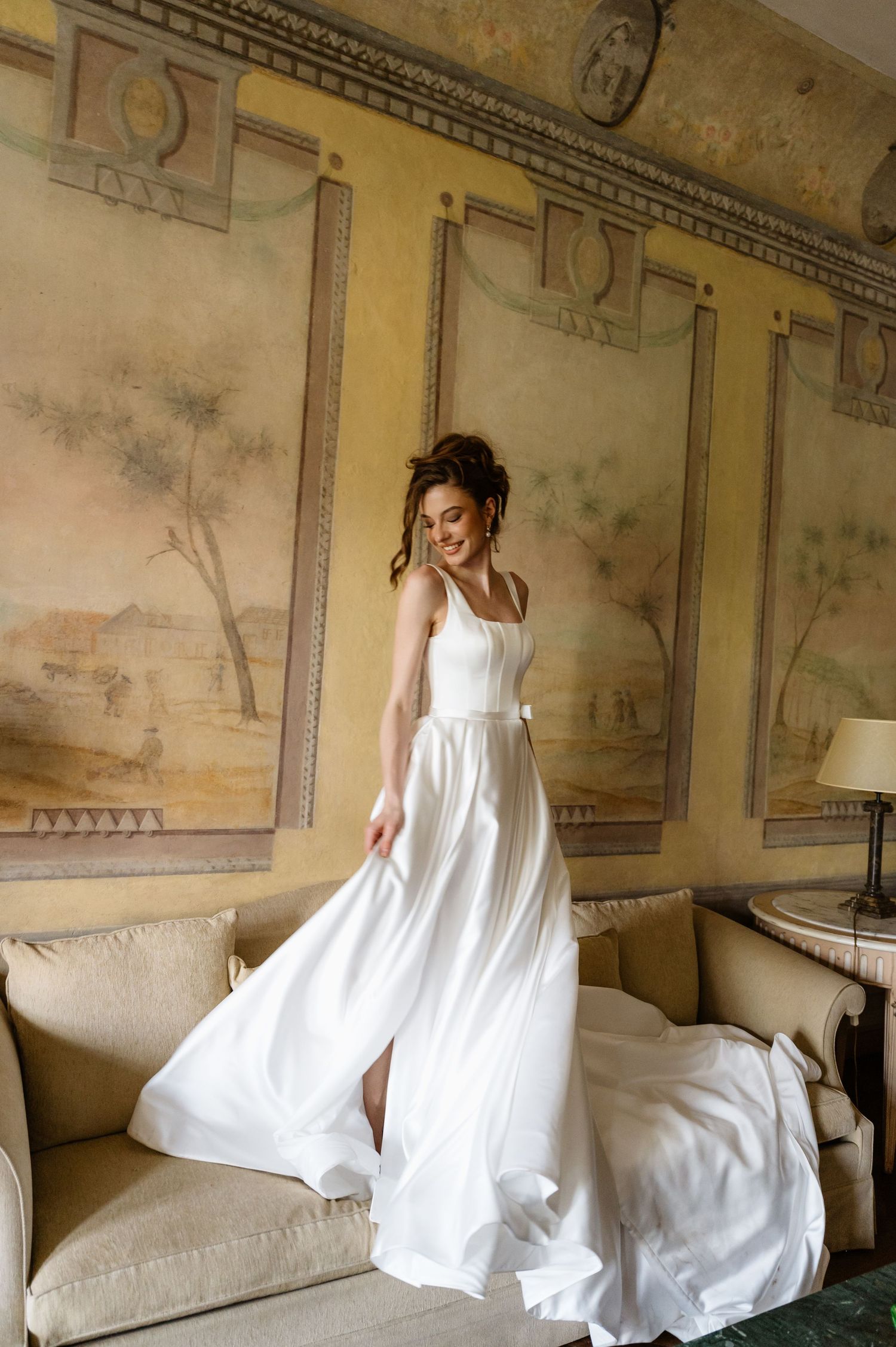 Artistic sequence of a flowing white dress movement in an elegant interior with fresco walls.