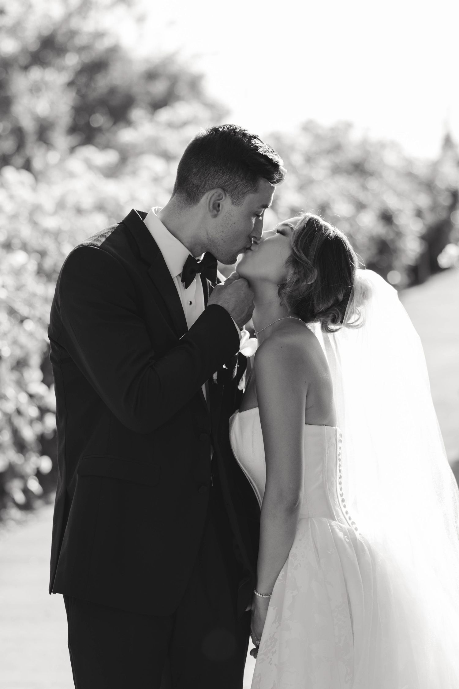 Artistic black and white photo series showing a tender romantic moment between newlyweds in an outdoor setting.
