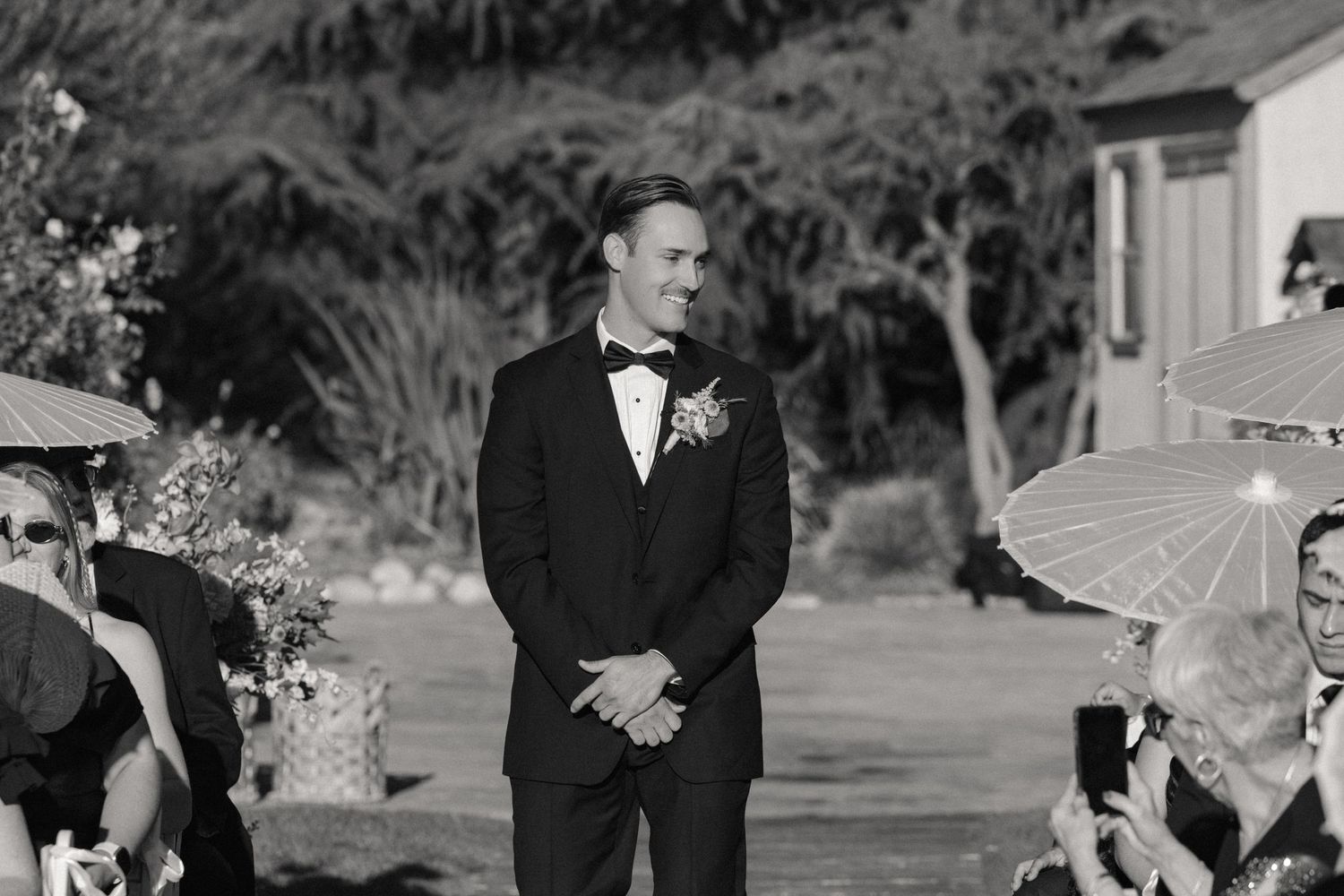 A black and white photo collage showing multiple wedding moments with couples and guests at an outdoor ceremony.