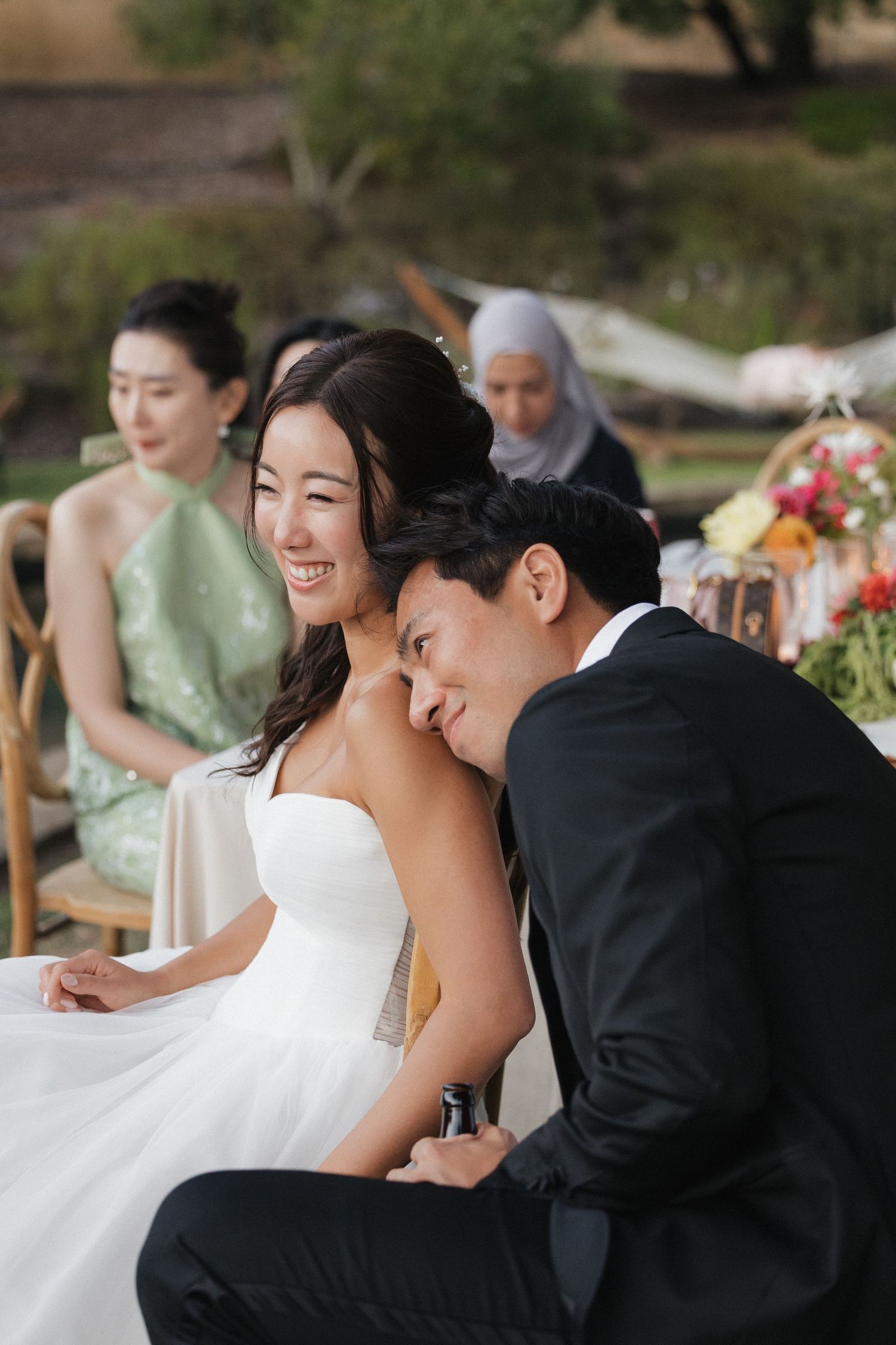 A couple shares an intimate moment at their outdoor wedding reception.